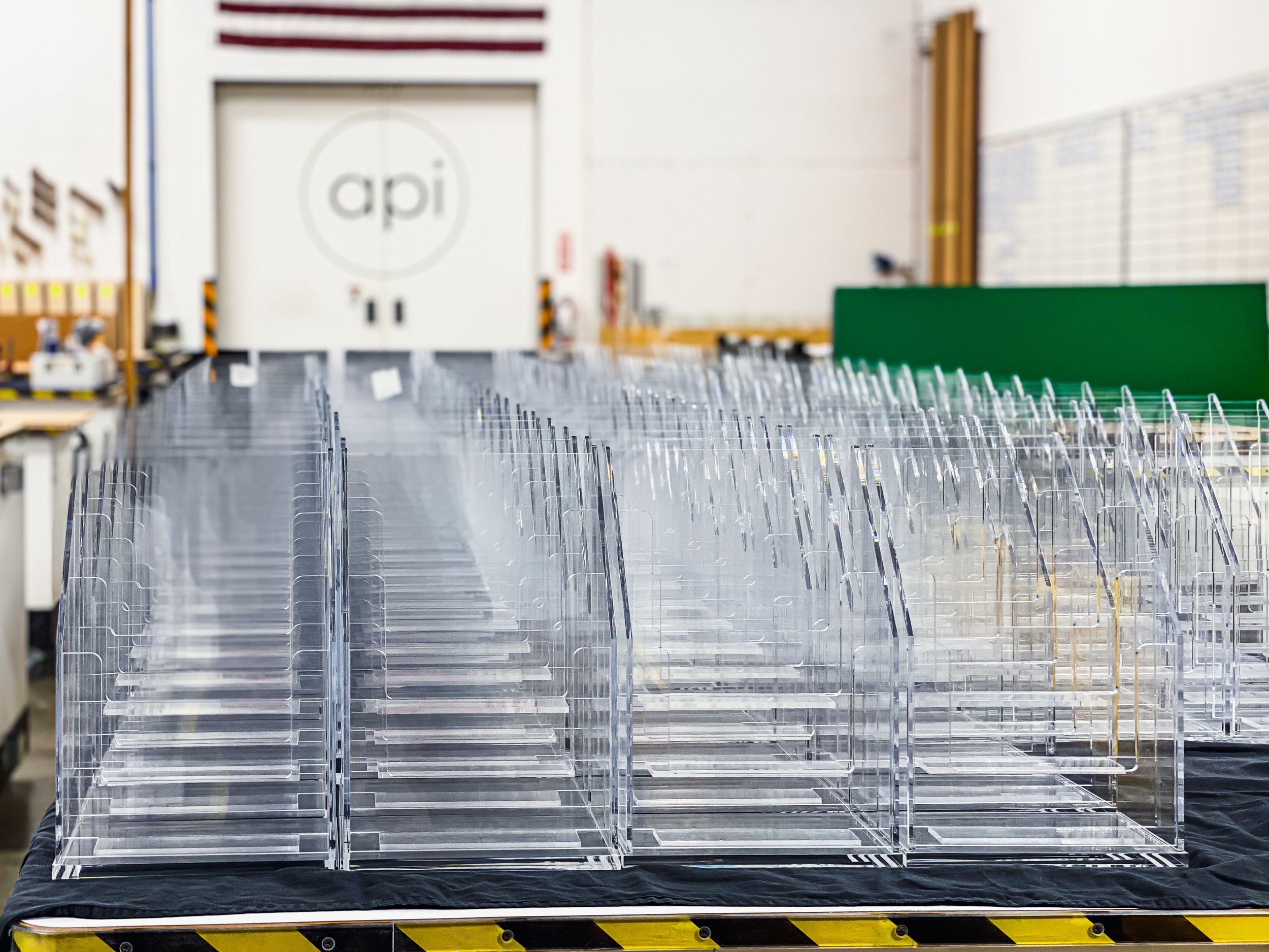 Dozens of clear acrylic brochure holders that have been glued and polished ready for packing.