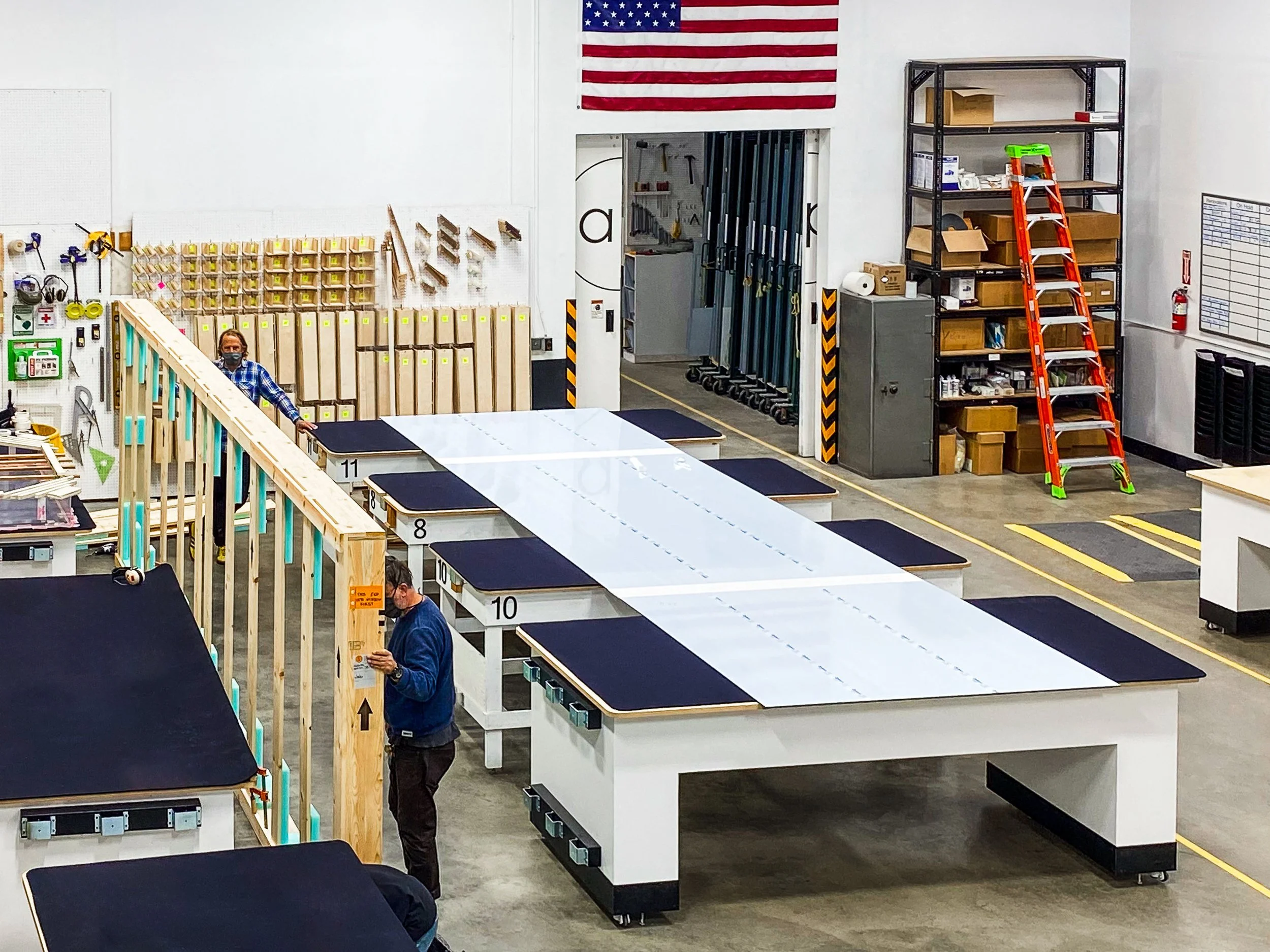 Long seamed acrylic panels bonded across multiple glue tables to maintain straightness, alignment, and seam consistency.