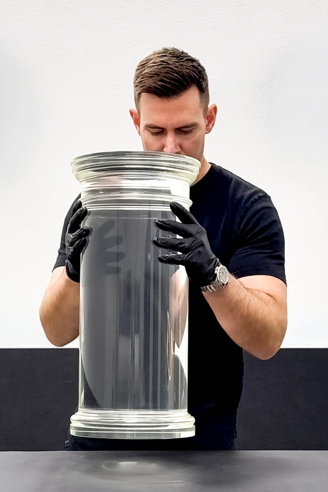 Man holding large cylinder of clear pmma acrylic.