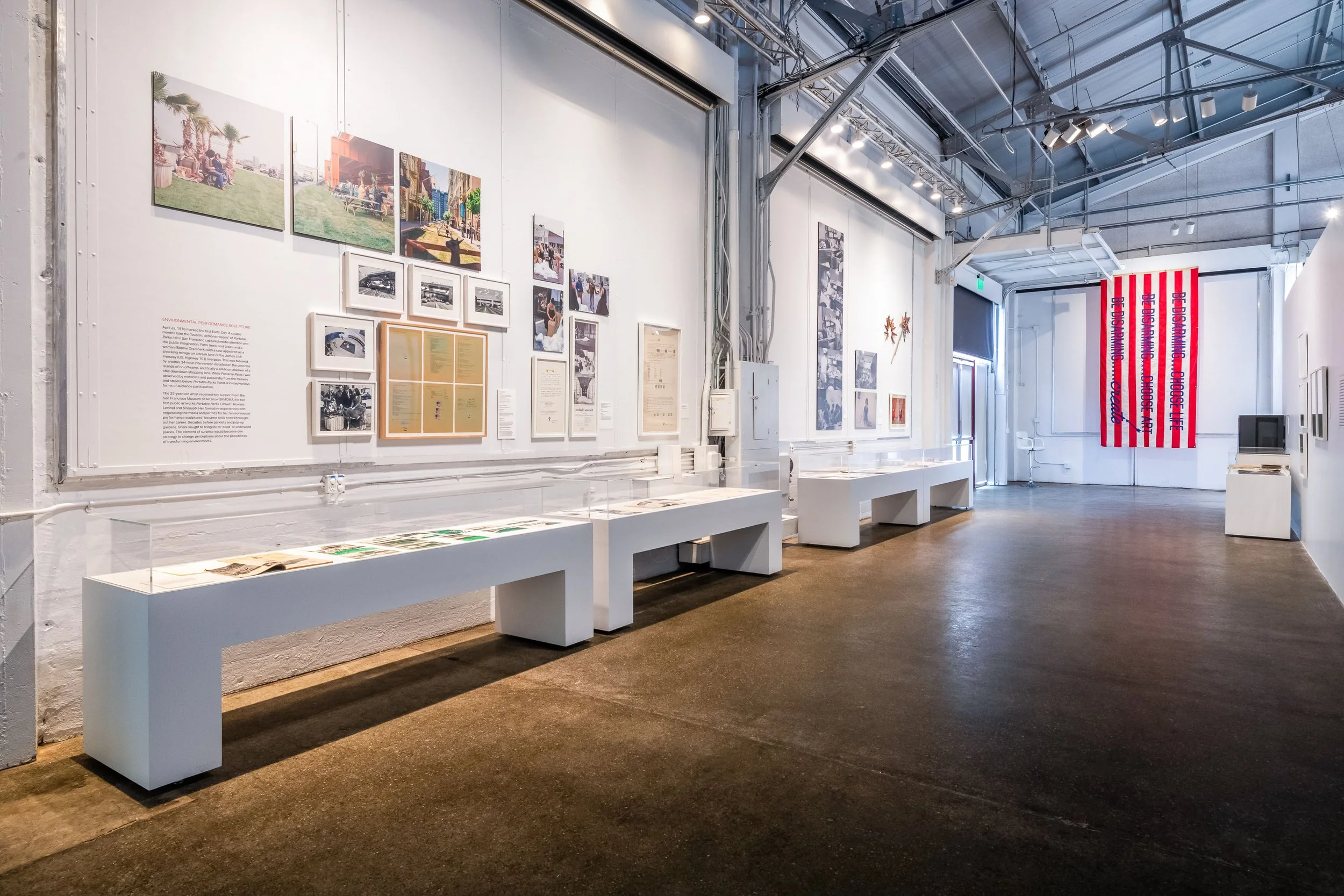 Minimal white painted pedestals with clear acrylic vitrine tops for a museum exhibit.