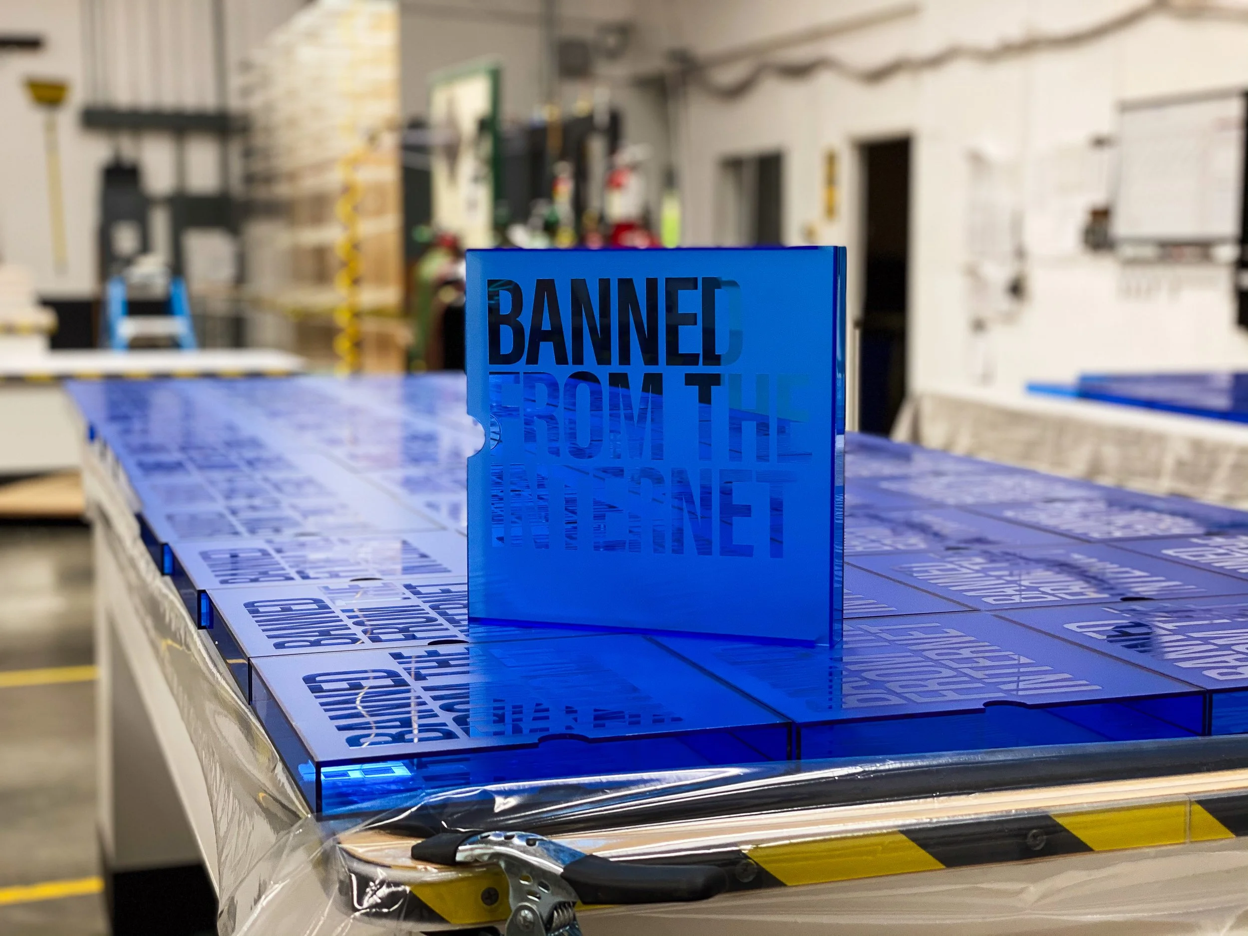 Bonded blue acrylic retail display panels staged after production, showing consistent seam quality across multiple units.