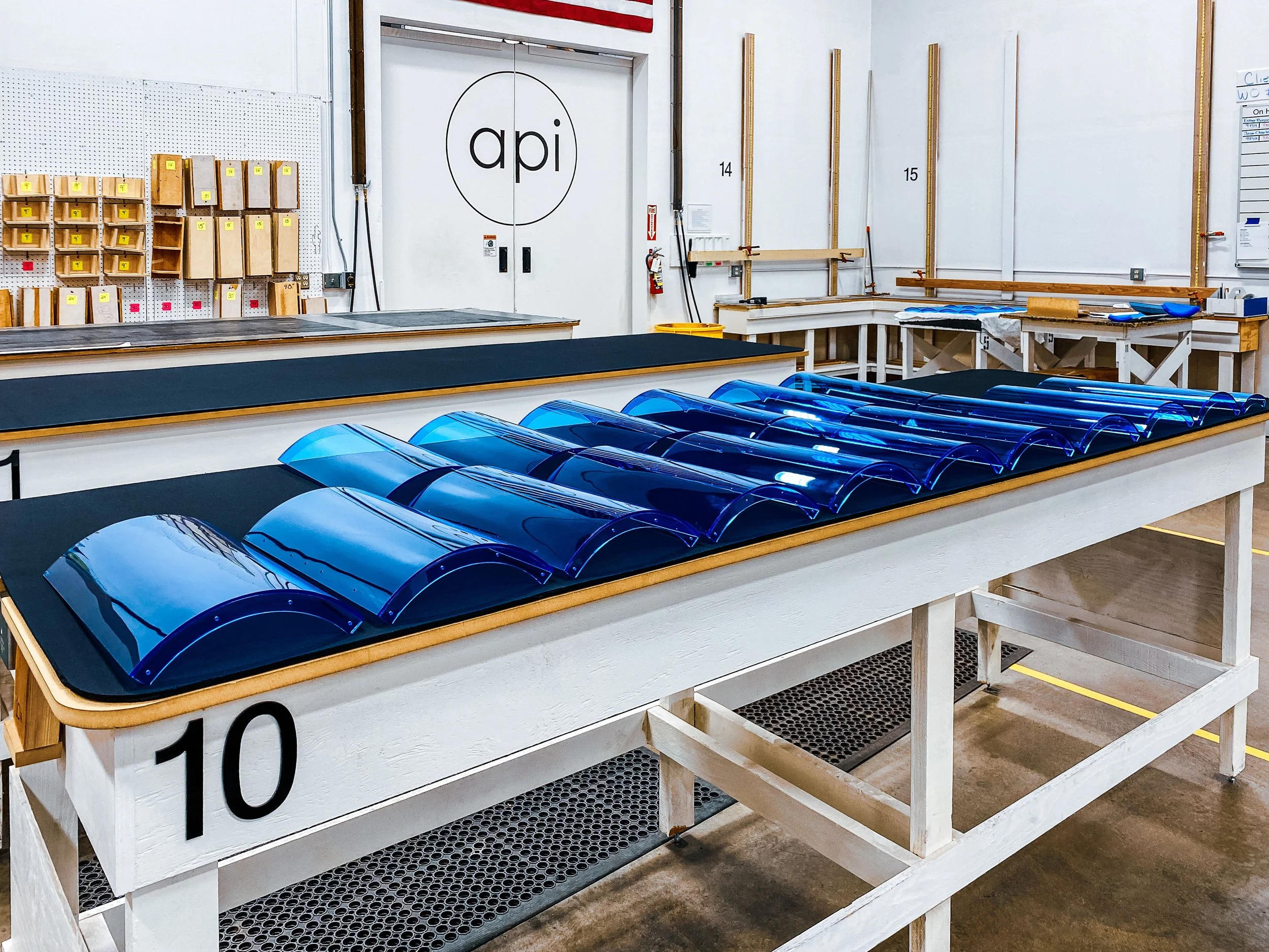 Thermoformed transparent blue acrylic curved doors with flanges glued to them for attachment to machinery.