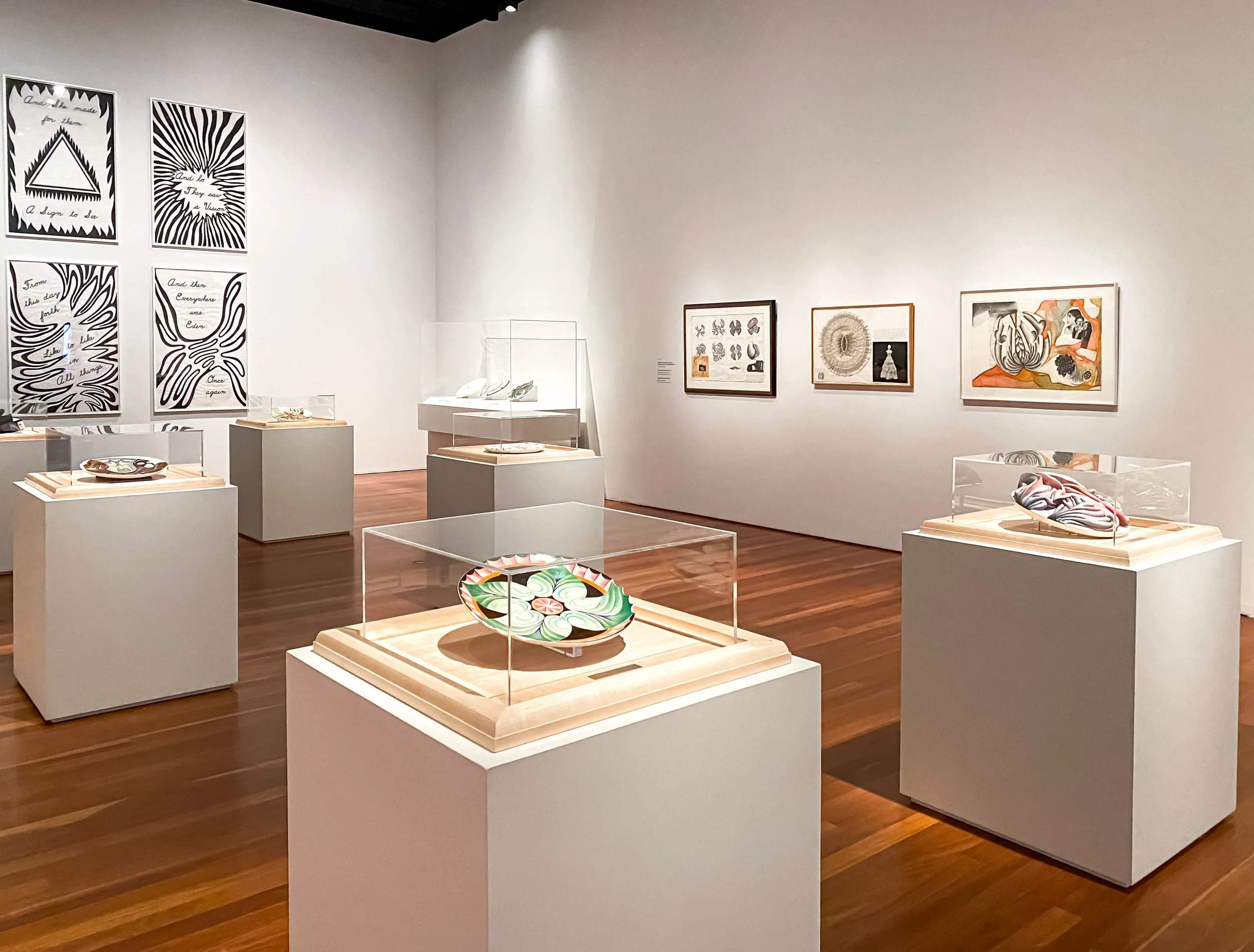 Custom acrylic display cases paired with white painted pedestal bases for a museum exhibit of decorative plates and bowls.