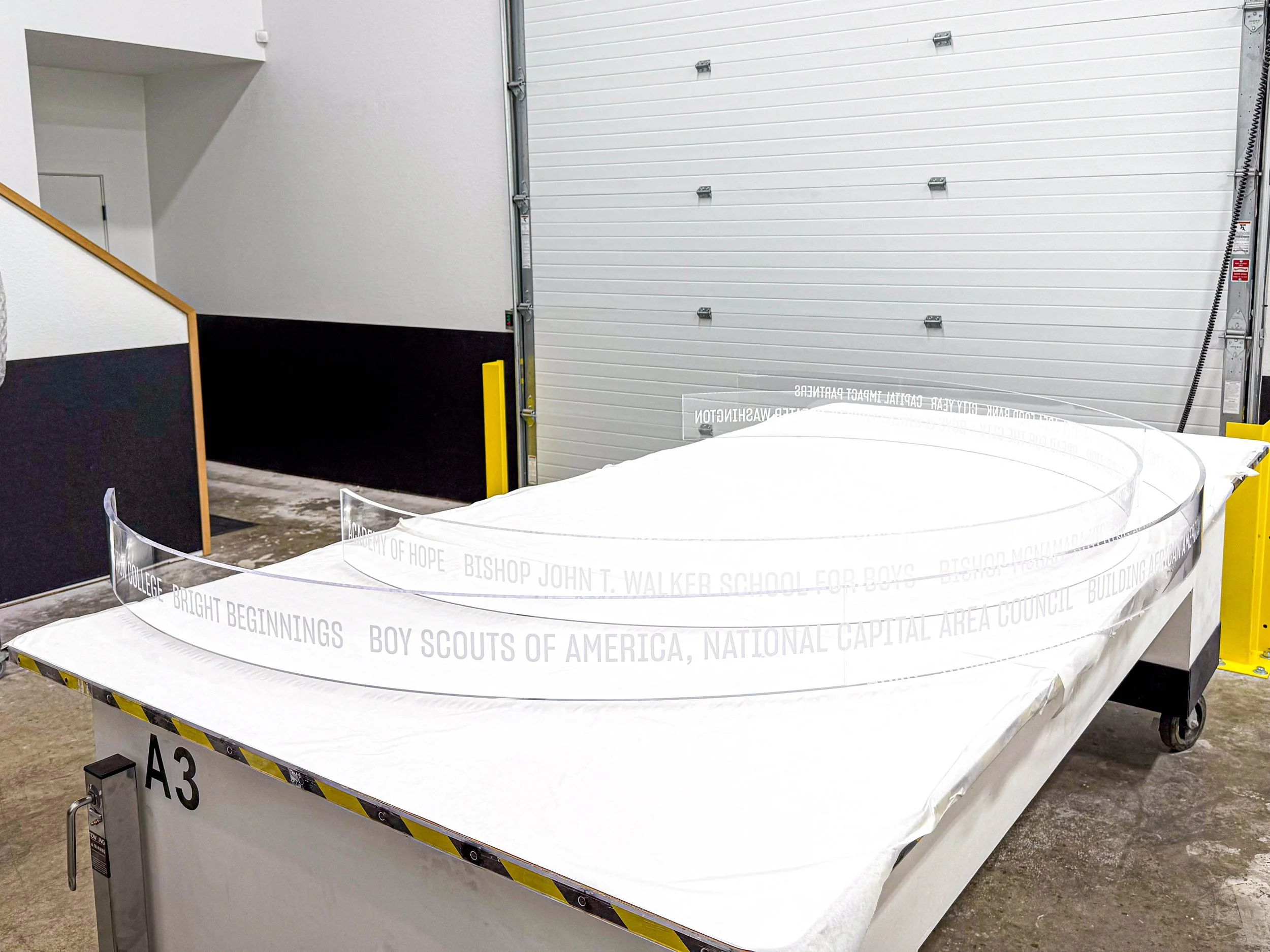 Thermoformed curved clear acrylic panels with letter detailing.