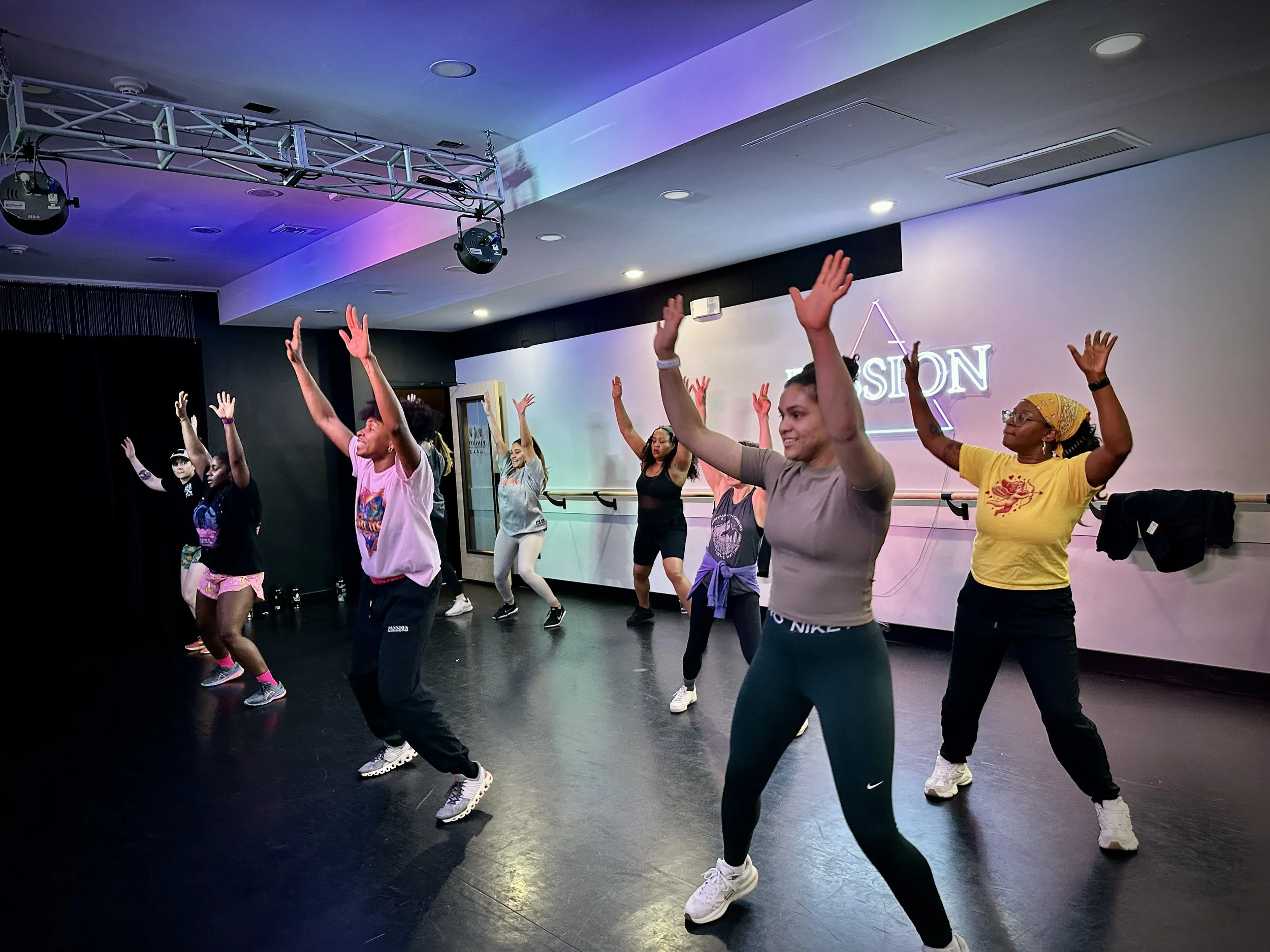 Group of people smiling during a dance class in a studio.