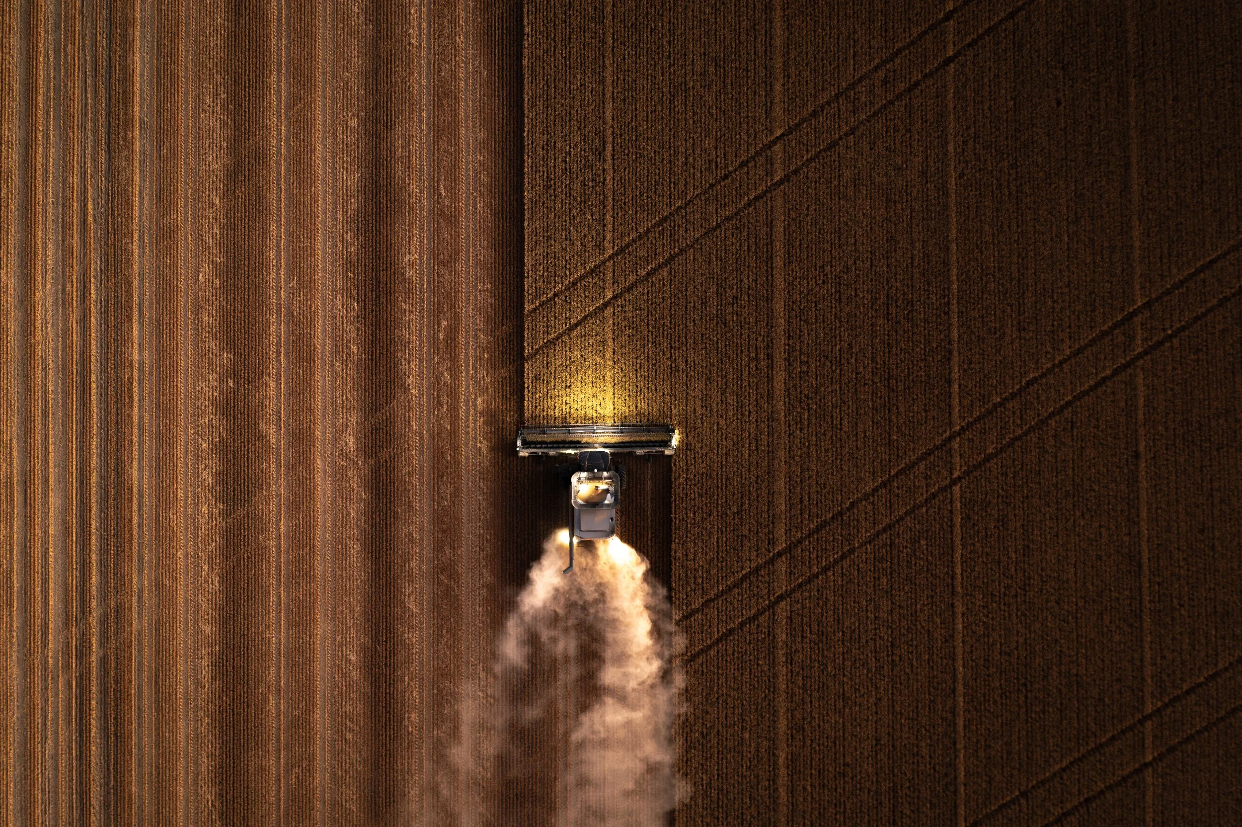 An aerial view of a cleaning drone spraying cleaning solution onto a large brown wooden or carpeted surface.