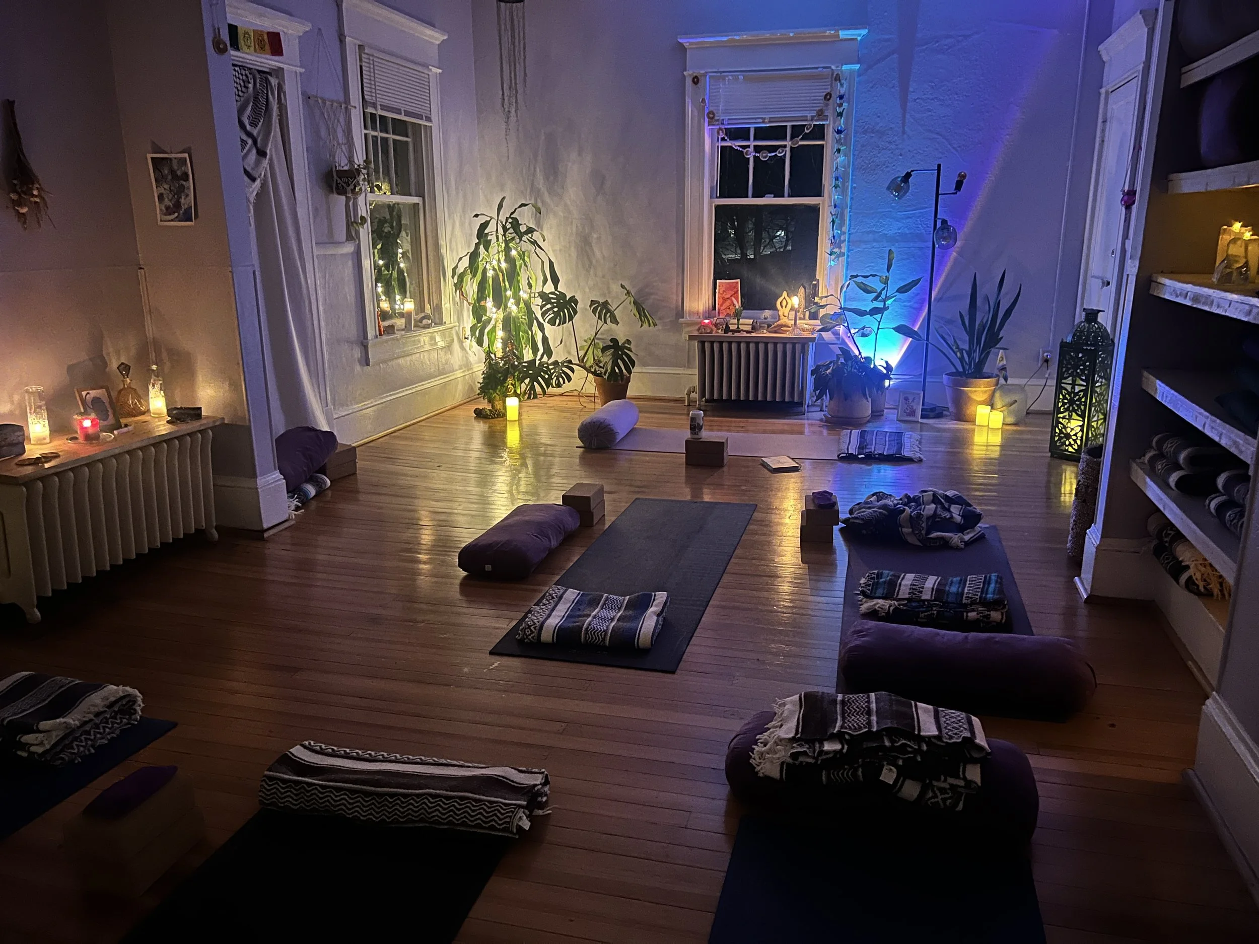 Yoga studio with yoga mats and props, low lighting with candles