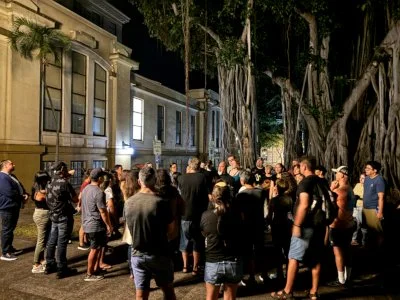 Guests gather beneath a century-old banyan tree on the haunted Honolulu Night Marchers ghost tour