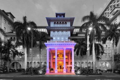 Black and white with spot color image of the haunted Moana Surfrider Hotel