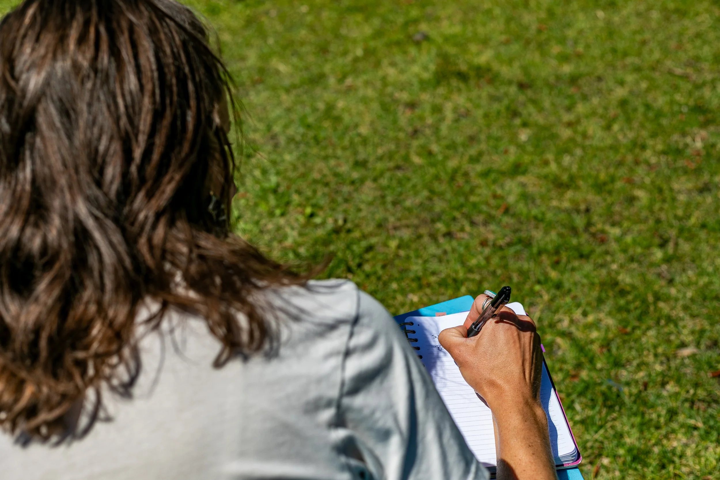 women outside sitting writing therapy notes