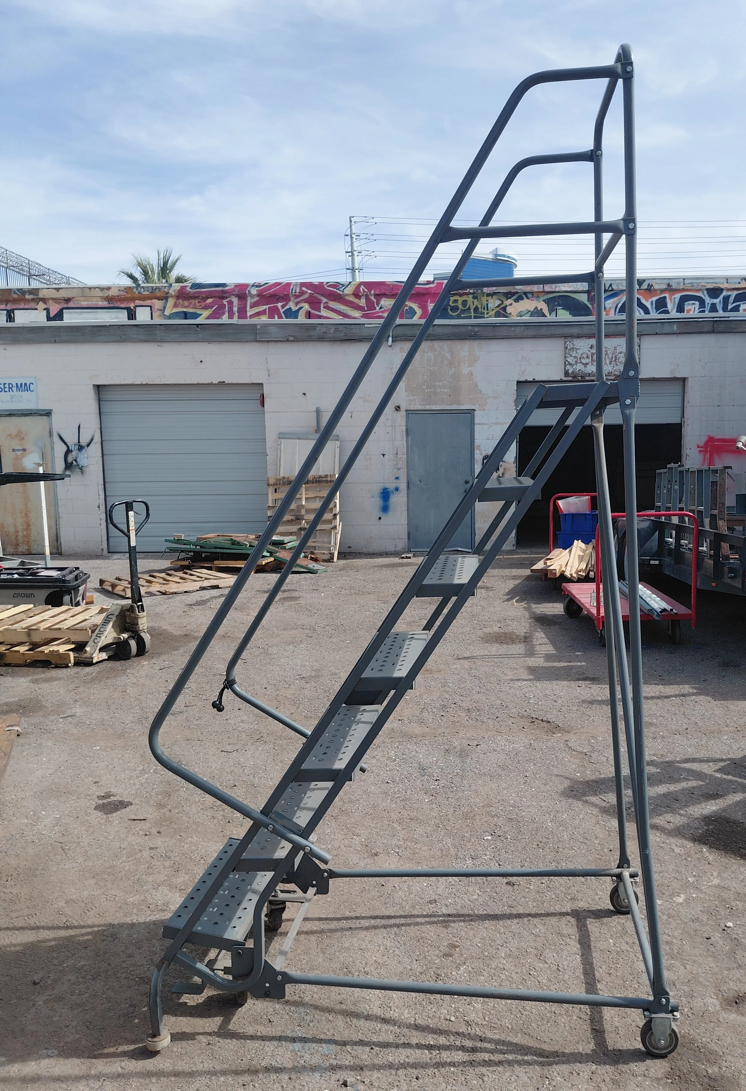 7-Step Rolling Warehouse Ladder. Top step is 70" high. Base is 35" wide x 56" deep.