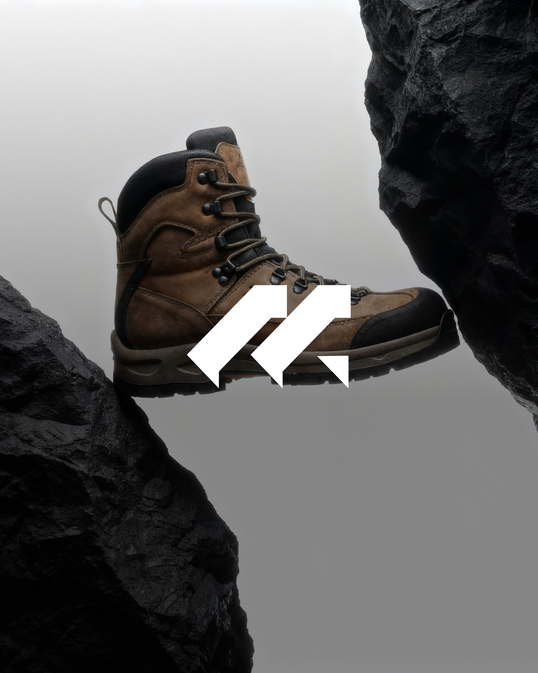 A brown hiking boot with black accents between two dark rocks.