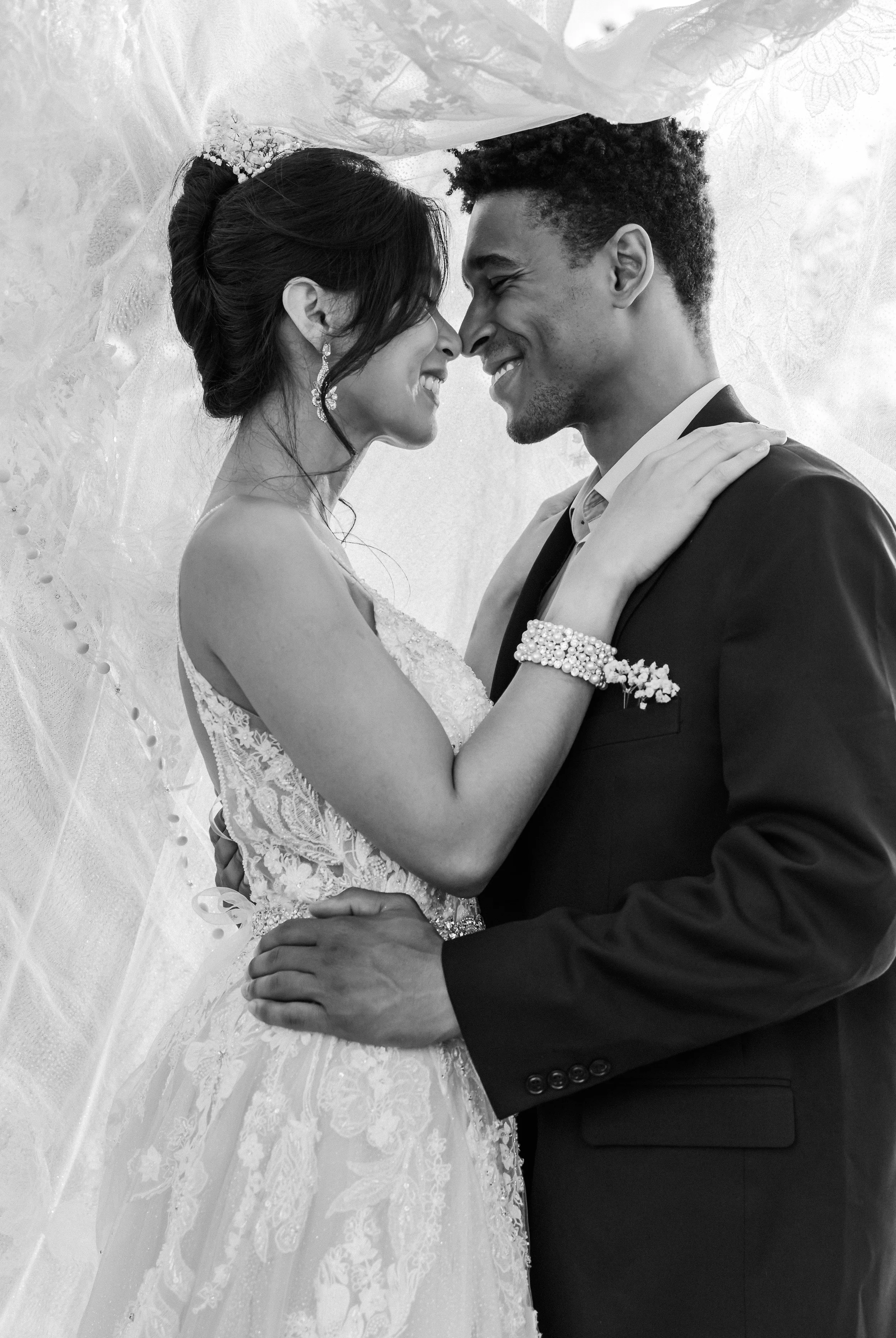 Bride and groom embrace under a veil, featured as a hero image for Kennedy Signature Events wedding planning and design services.