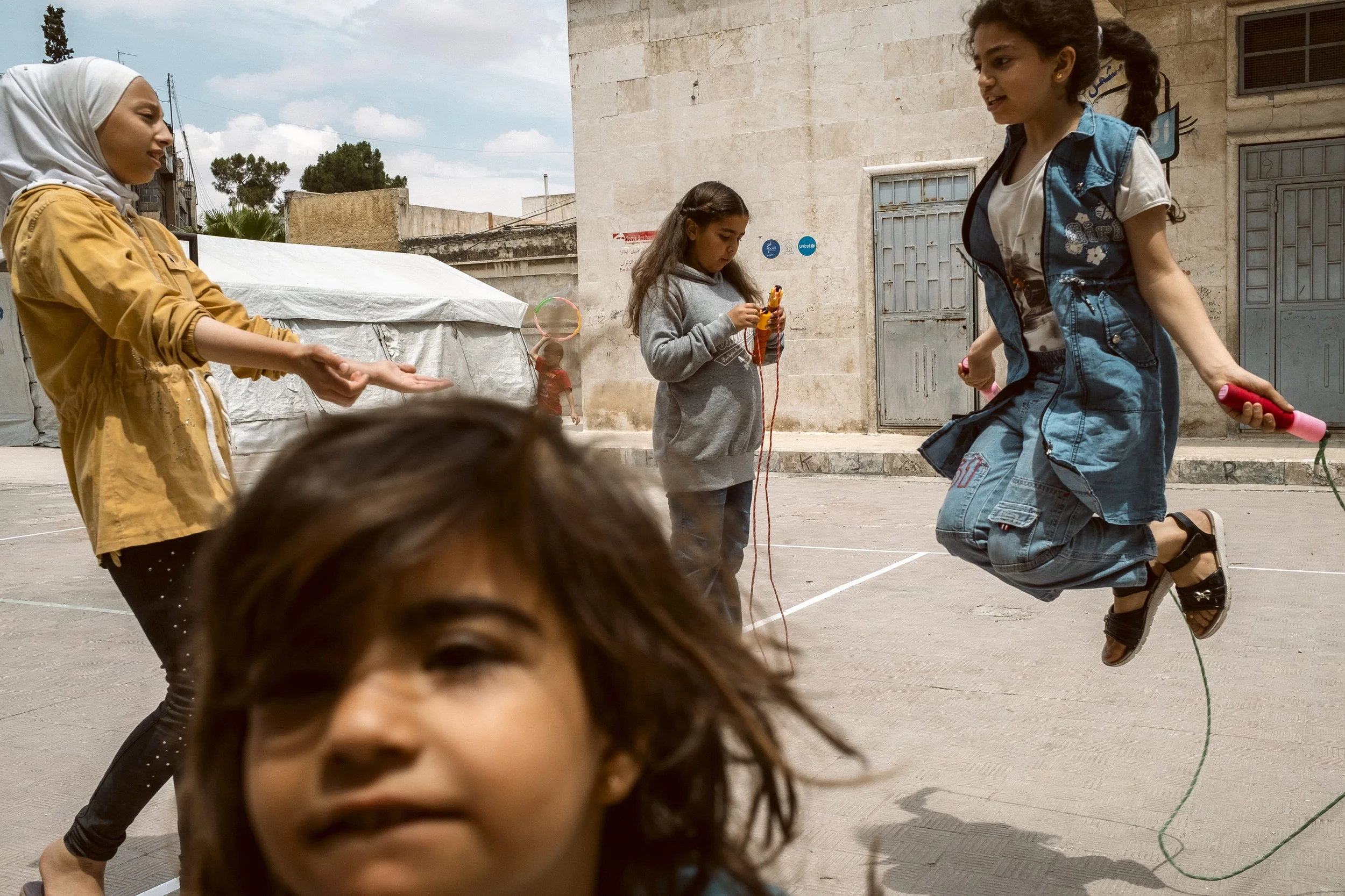 Children play skipping rope in the courtyard of a school in Aleppo, Syria. After the February 2023 earthquake, the school was turned into emergency accommodation for families who had lost their homes.