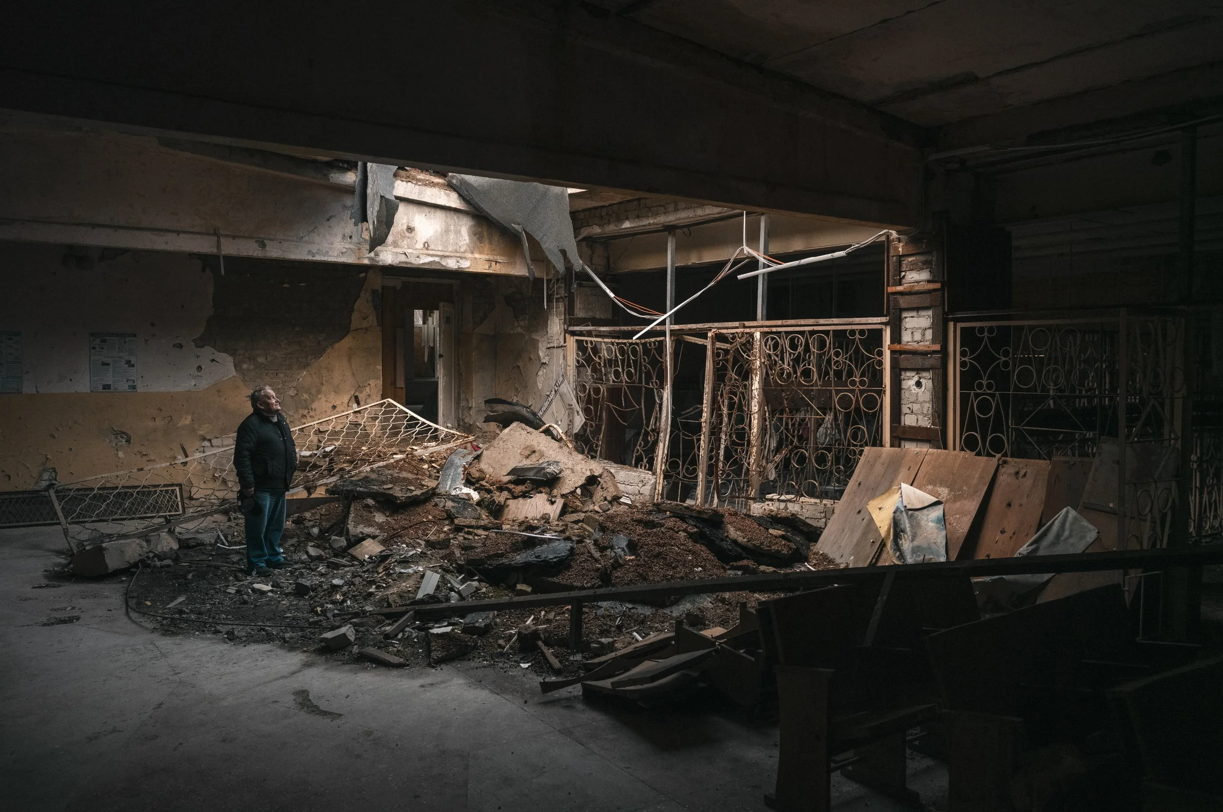 Oleksander Grianyk, principal of Kharkiv School Number 62, stands in the damaged lobby, recounting the night of April 8, 2022, when the school in Piatyhatky was heavily bombed. The school sustained significant damage, most notably in the Russian lang