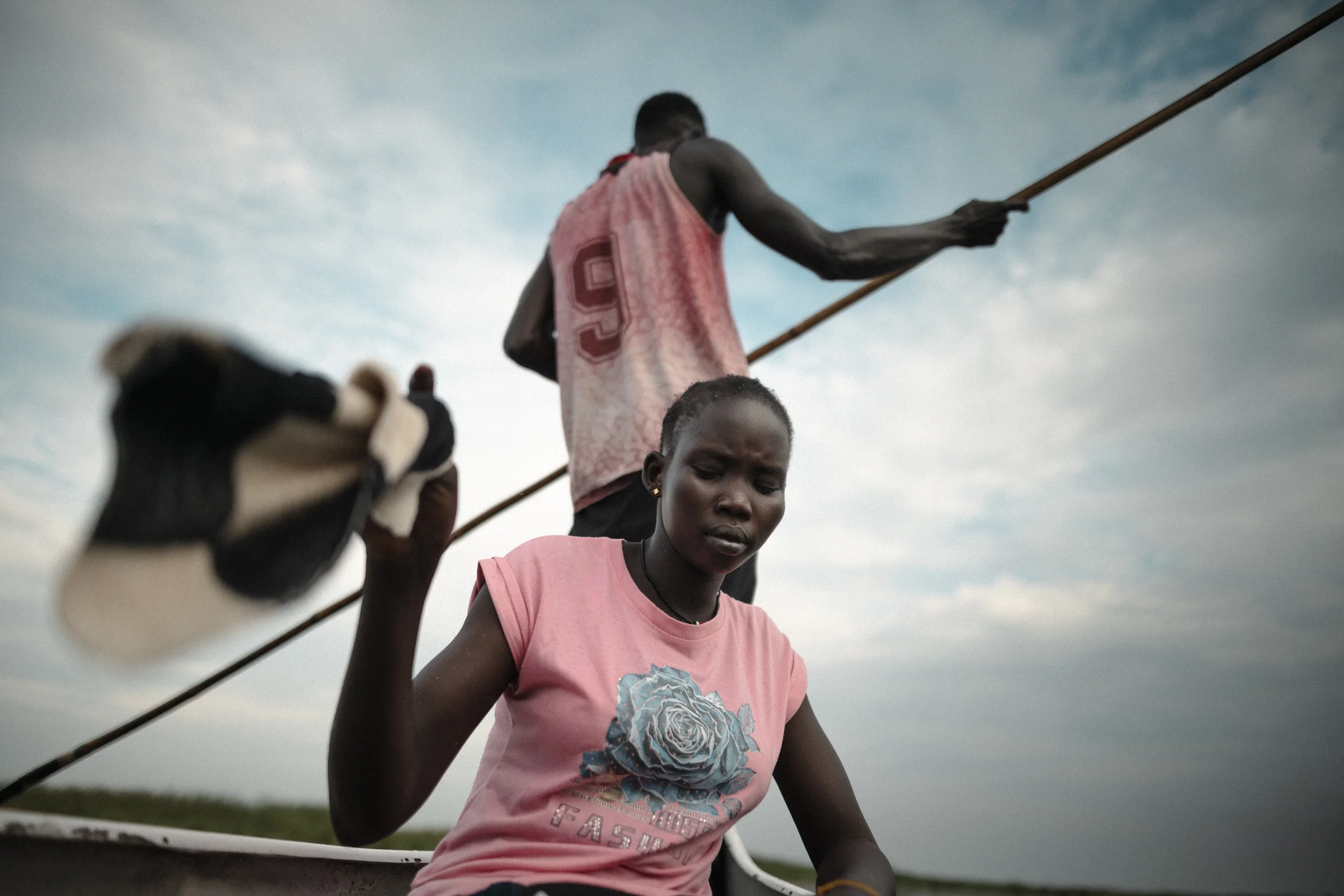 Nyaluak Deng Nger uses a small towel to drive away mosquitoes during the canoe journey back to Paguir after visiting her father, Deng Nger Wuor. A route once walked over dry land now takes seven or eight hours by local canoe.