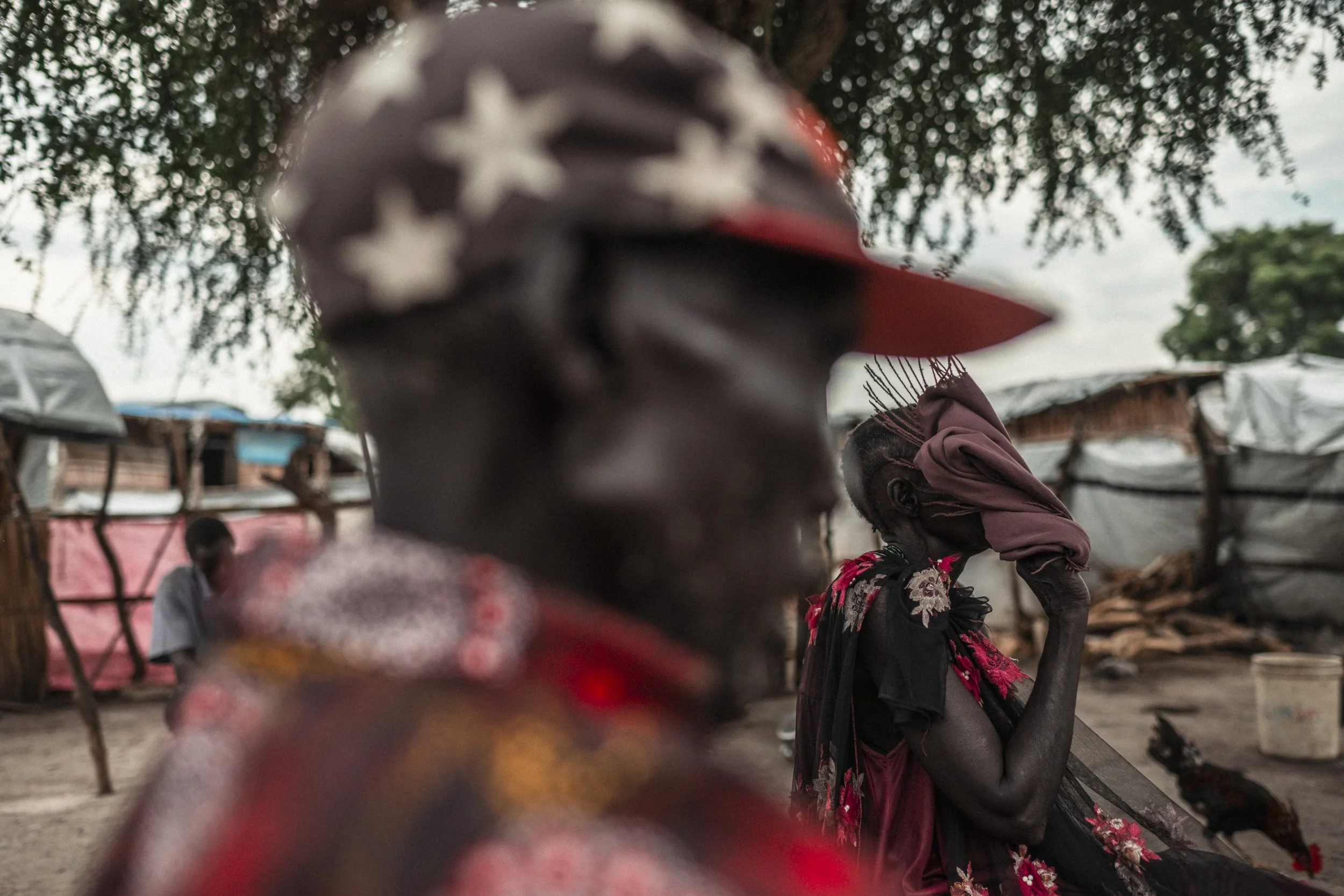 Nyadak Muon Nhial, in focus behind her husband, Deng Nger Wuor, during his visit to the family in Paguir. Deng had travelled for nine hours to reach them. The couple live apart so their children can attend school: Nyadak stays with them in Paguir, wh