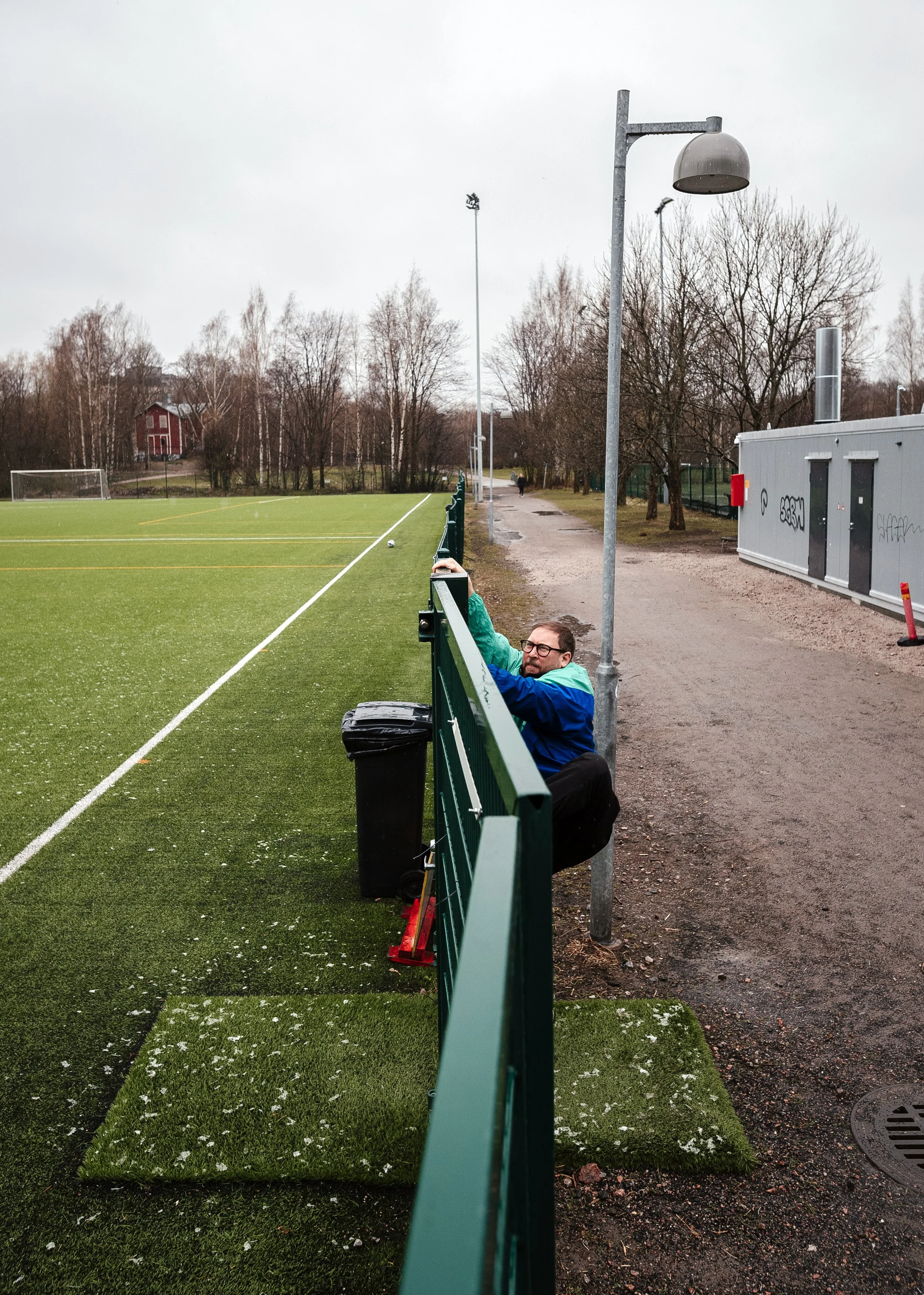 MP Paavo Arhinmäki, former Minister for Culture and Sport, tries to get onto the football pitch of his childhood, now fenced. He has written a book about supporting the Finnish national team. Helsinki, April 2021. For Kansan Uutiset.