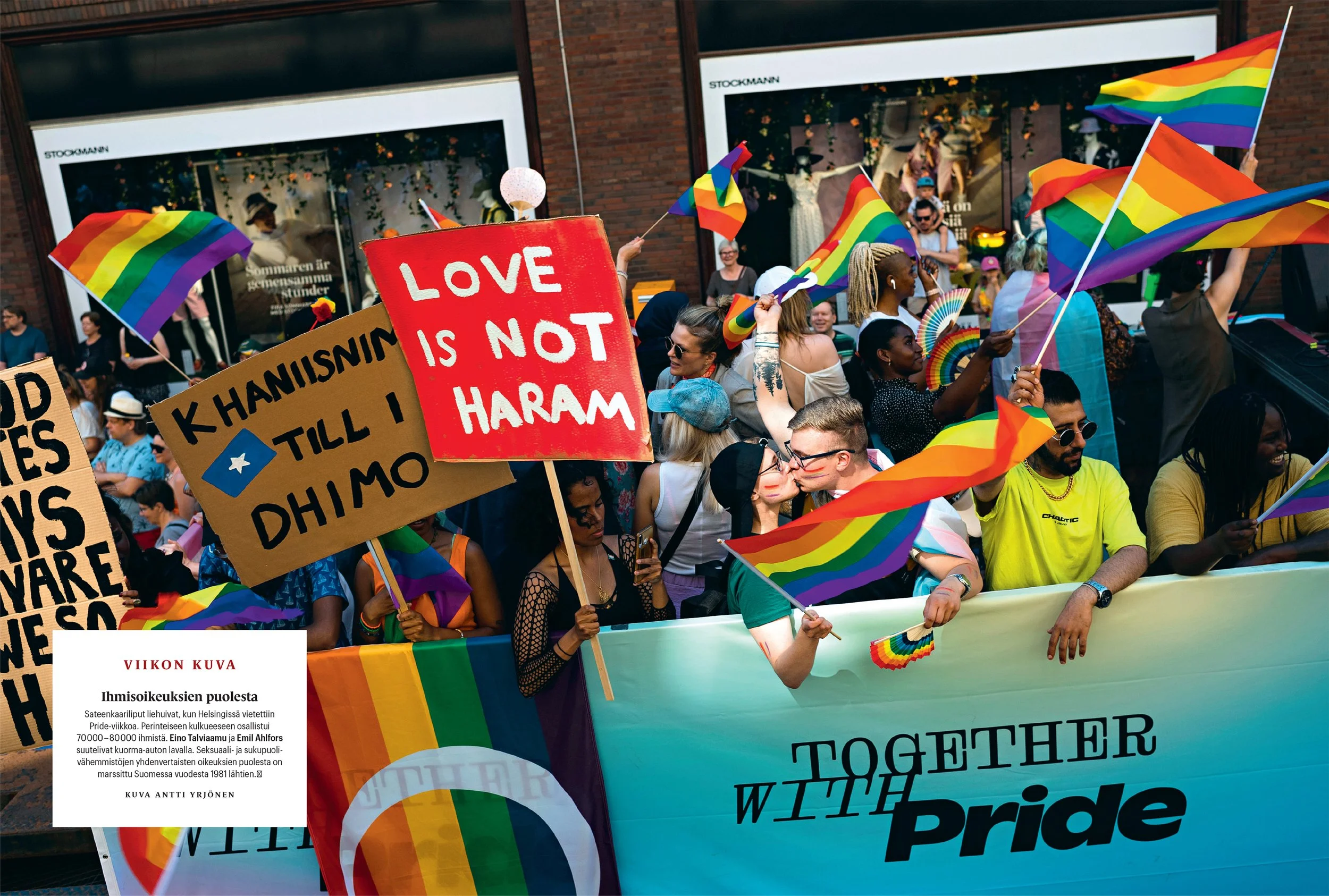 A colorful Pride parade with participants holding rainbow flags and signs saying "LOVE IS NOT HARAM" and "TOGETHER WITH PRIDE."