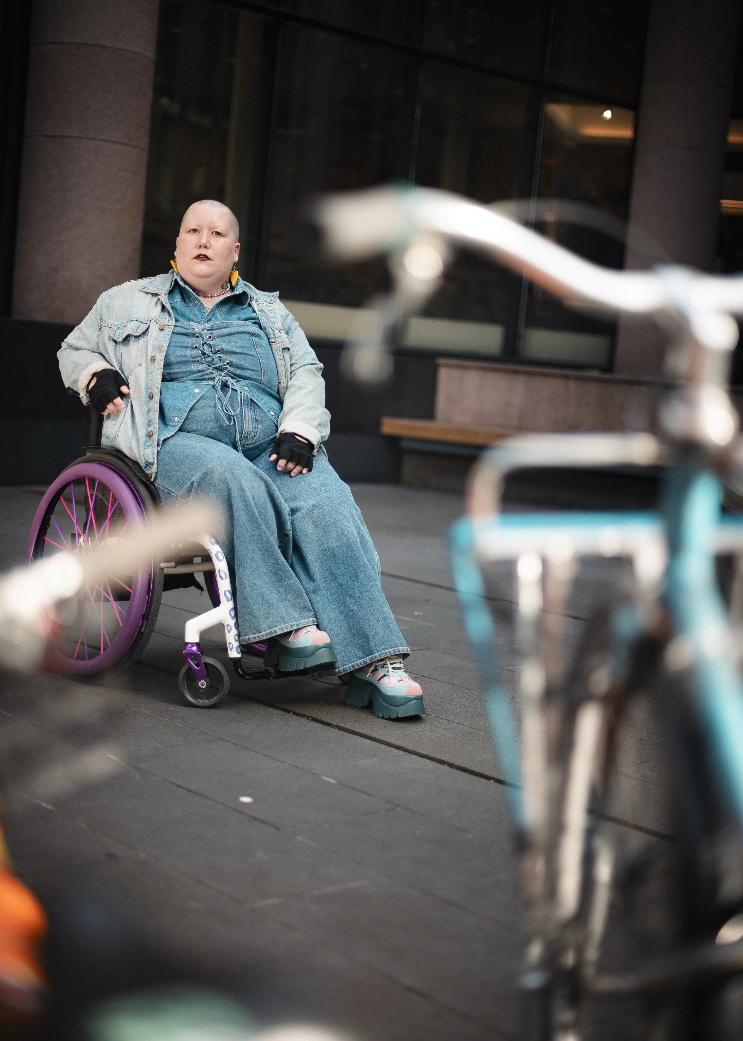 Disability activist Sam Brandt-Smal in their customised wheelchair, "Sähäkkä Sanna". With few aesthetic options offered for mobility aids, Brandt-Smal sources colour and pattern elsewhere. Turku, September 2025. For IT-lehti.