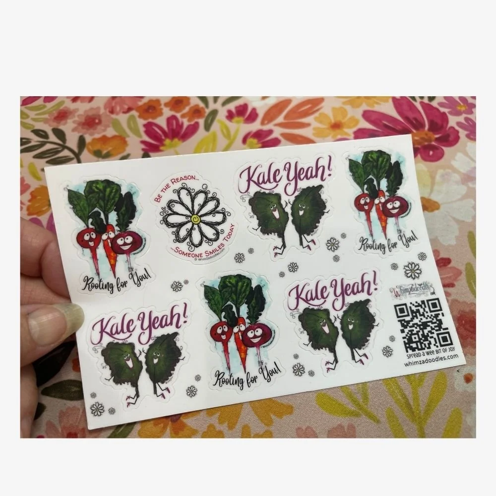 Hand holding the Cheer Someone On watercolor sticker sheet showing colorful encouragement stickers and the size of the sheet.