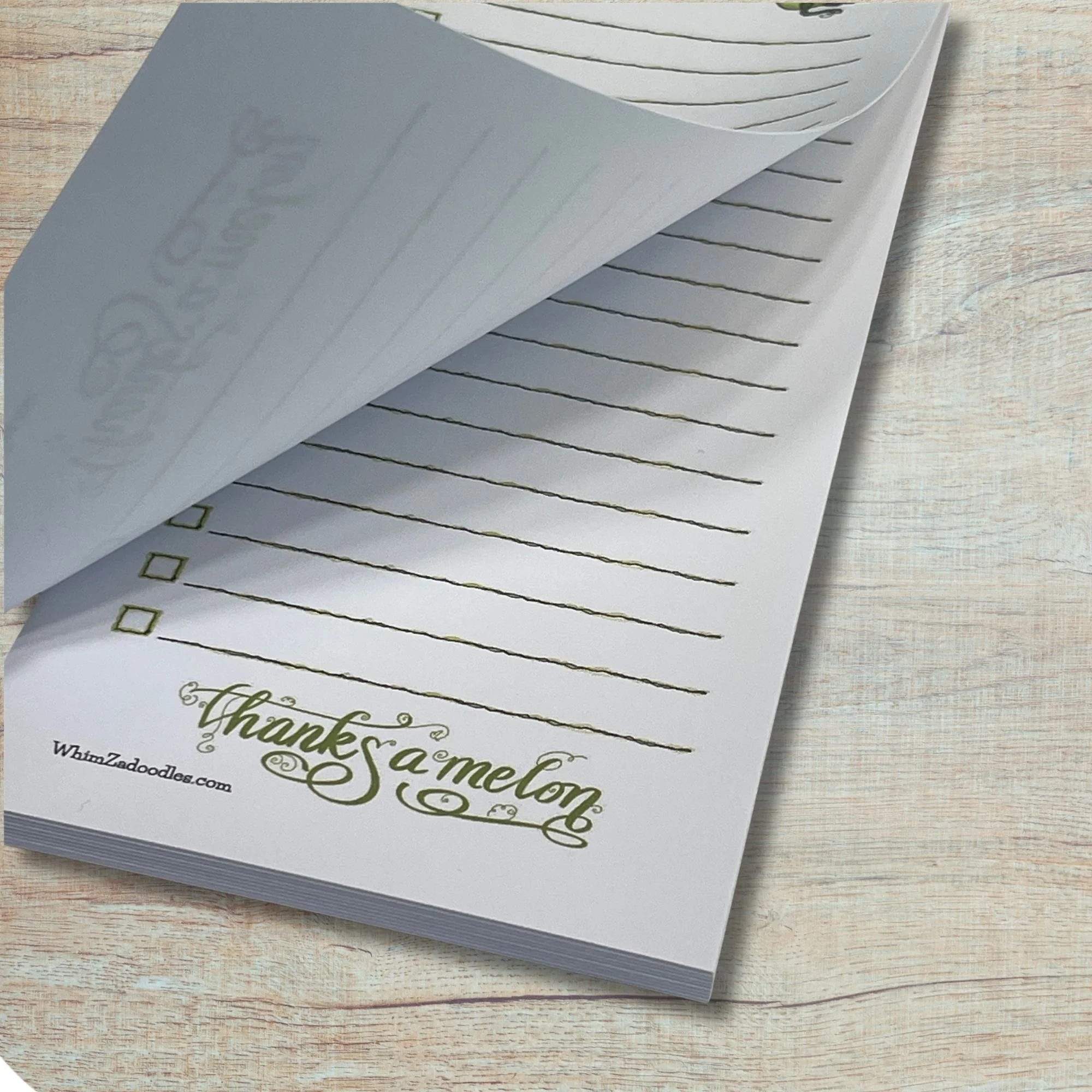 Close up of honeydew list notepad with a page gently lifted showing tear-away paper and clean stacked sheets beneath