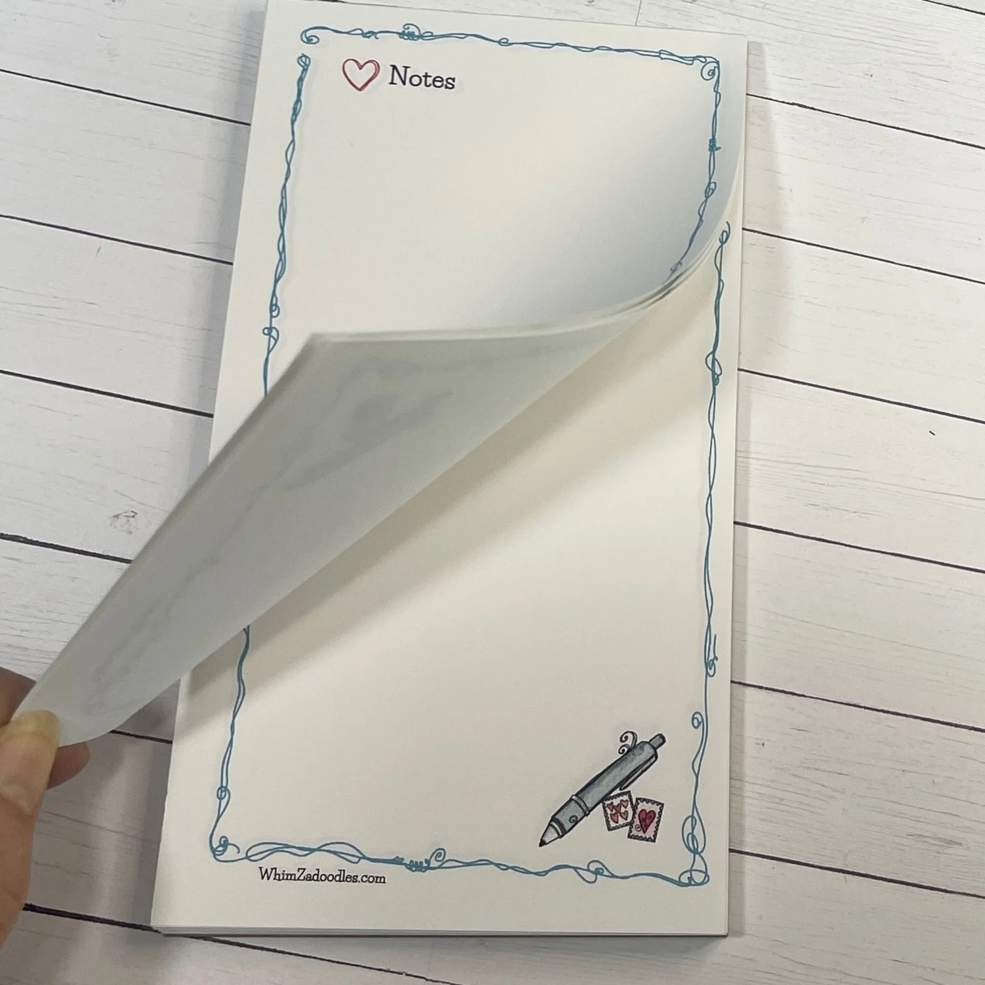 Close-up of bottom corner featuring whimsical pen and stamps illustration with fine doodle detail on white paper