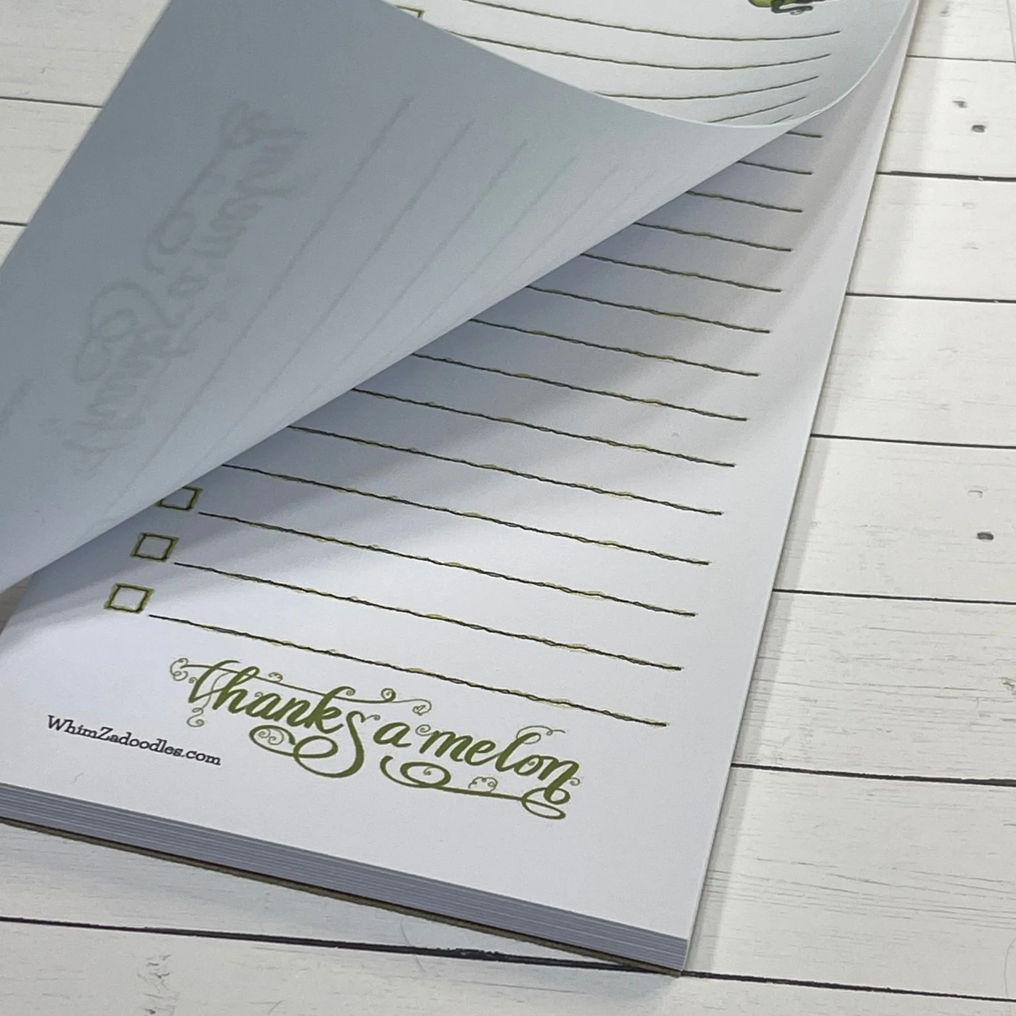 Close up of honeydew list notepad with a page gently lifted showing tear-away paper and clean stacked sheets beneath