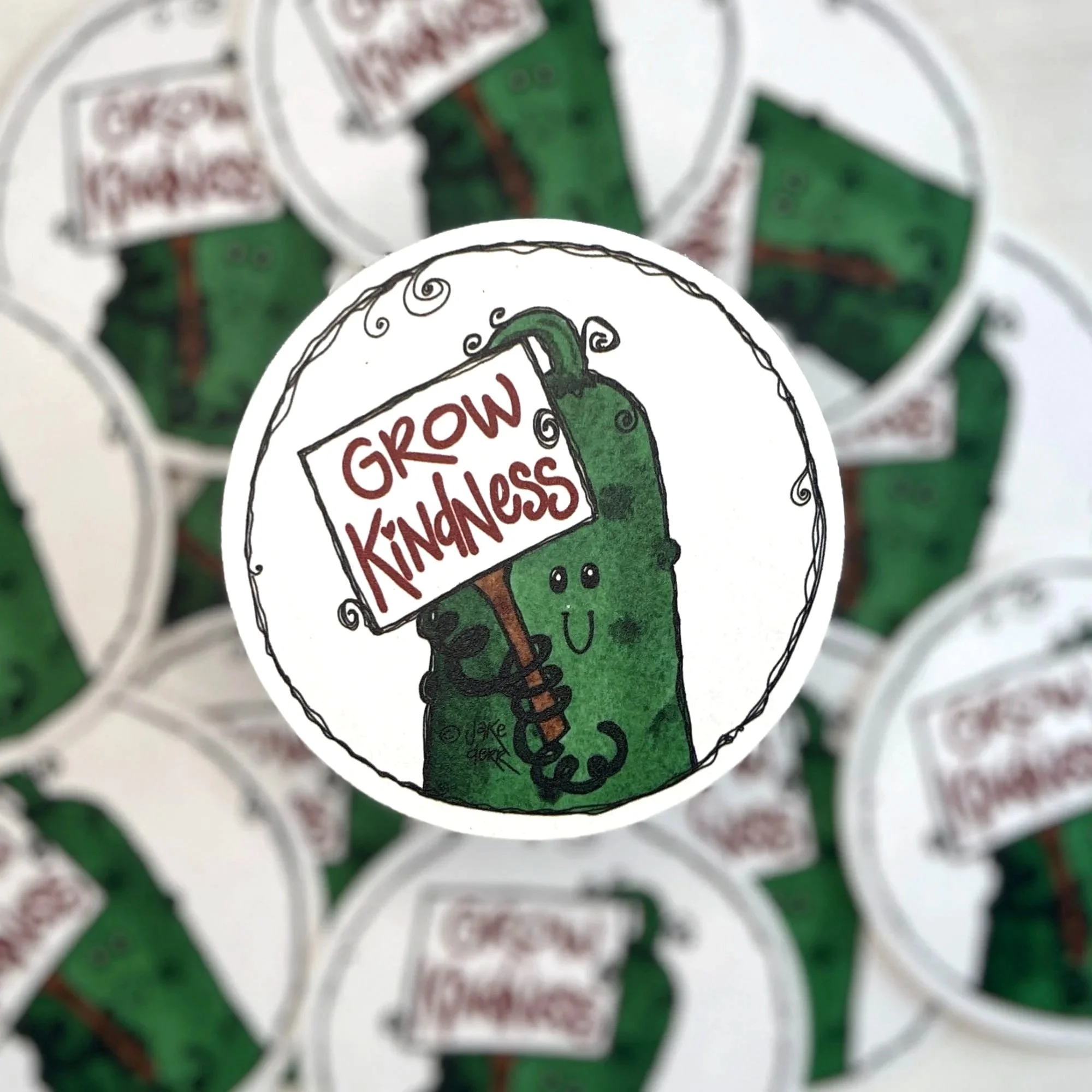 Cultivating Kindness Crew coaster highlighted above blurred stack showing artwork focus
