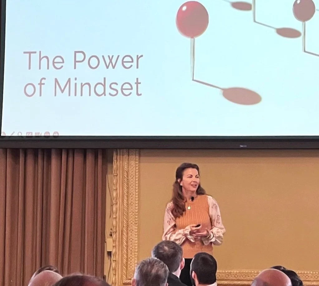 Traci giving a keynote presentation titled 'The Power of Mindset' at a conference for executive leaders.