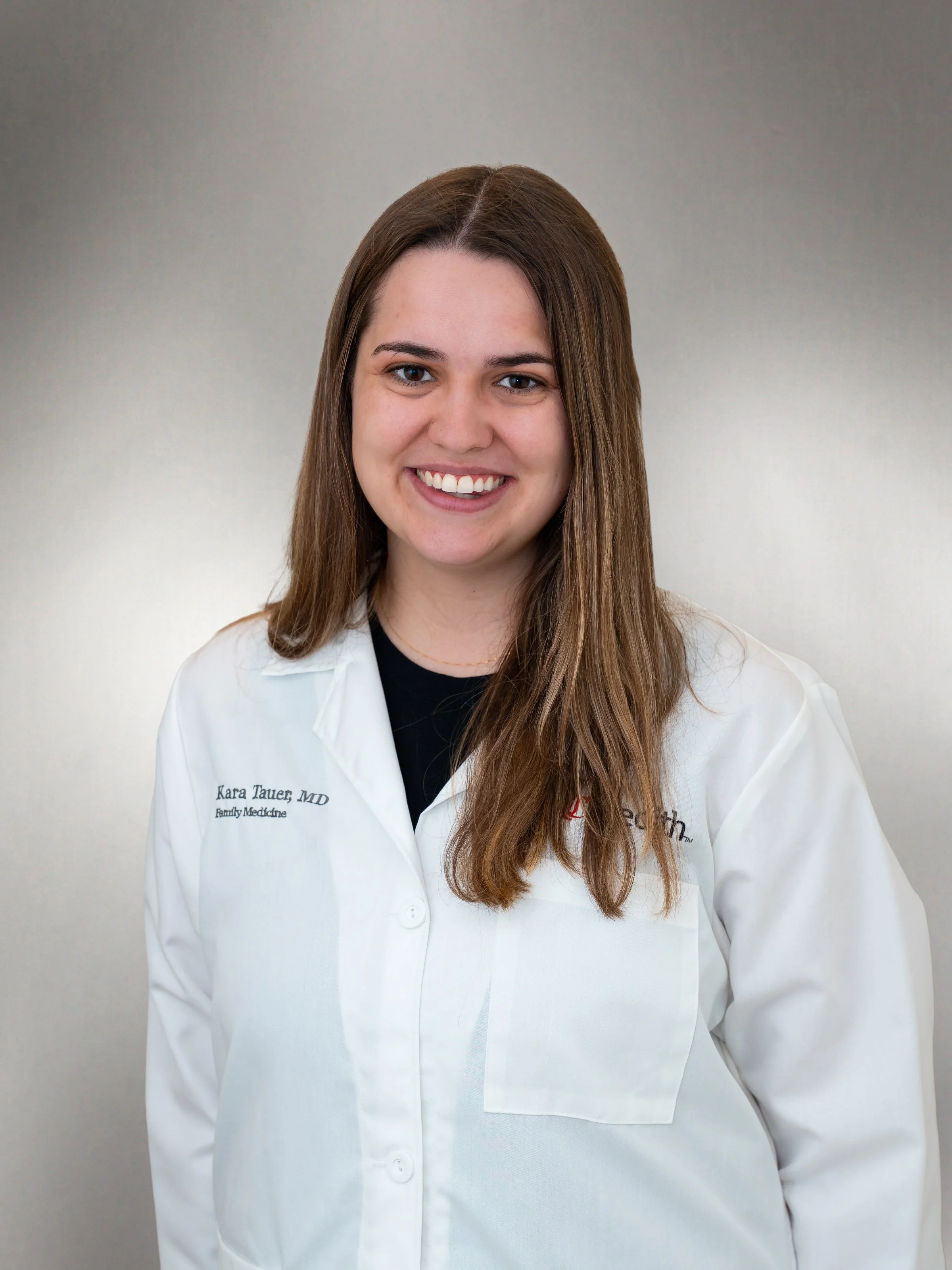 Dr. Kara Tauger wearing a white lab coat in a professional headshot.Dr.  Ishita Sachdeva