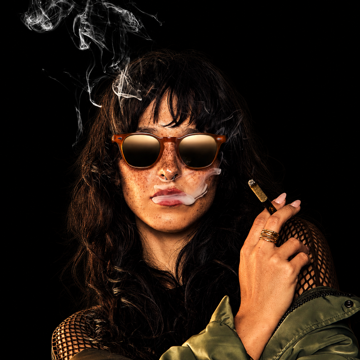 Maven model wearing sunglasses smoking a Halo, a hash-filled pre-roll.