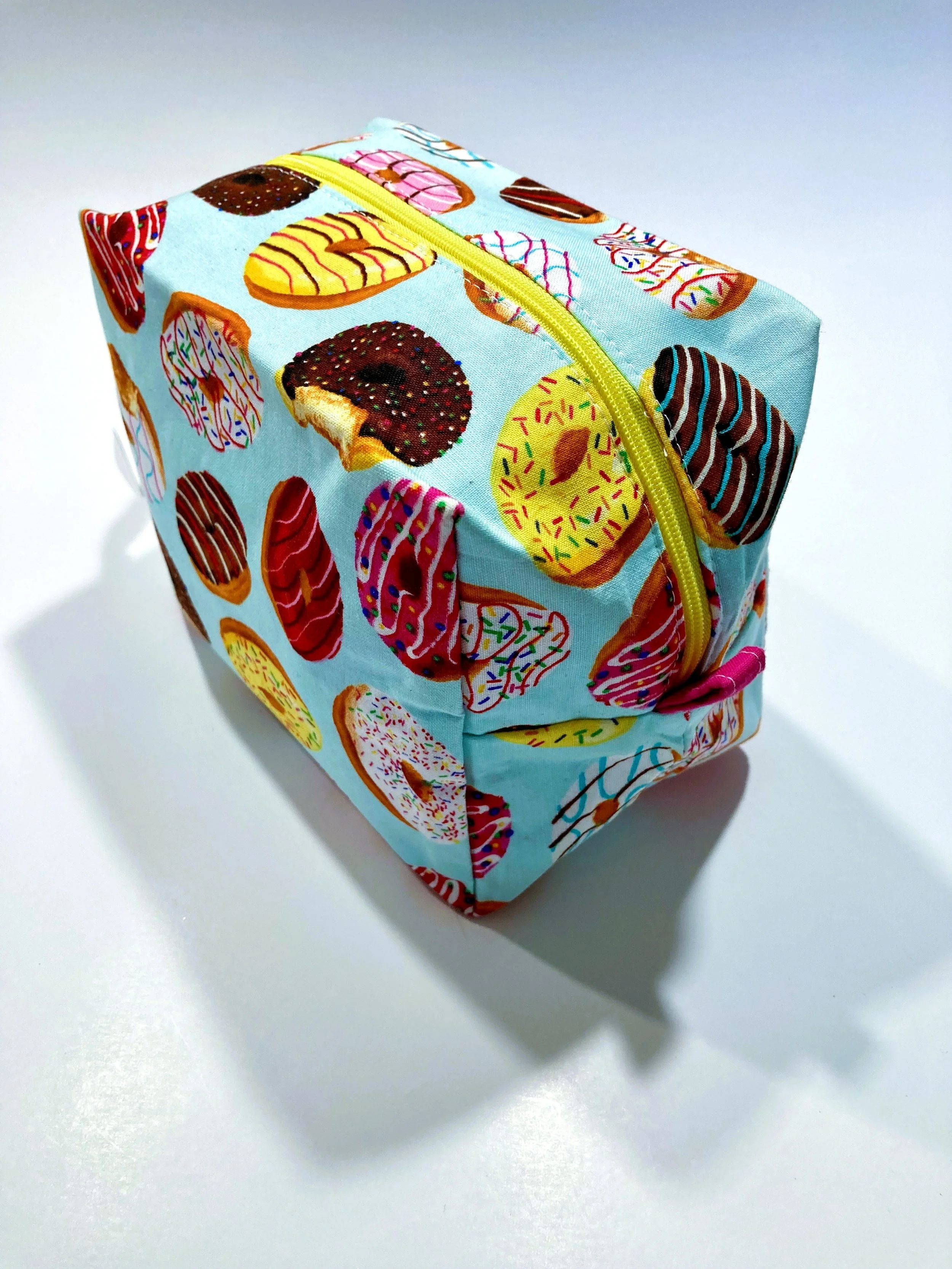 Bright Donuts Print Travel Cosmetic Bag Vibrant Sprinkle Pattern Makeup Case with Hot Pink Interior View Side Angle View.jpeg