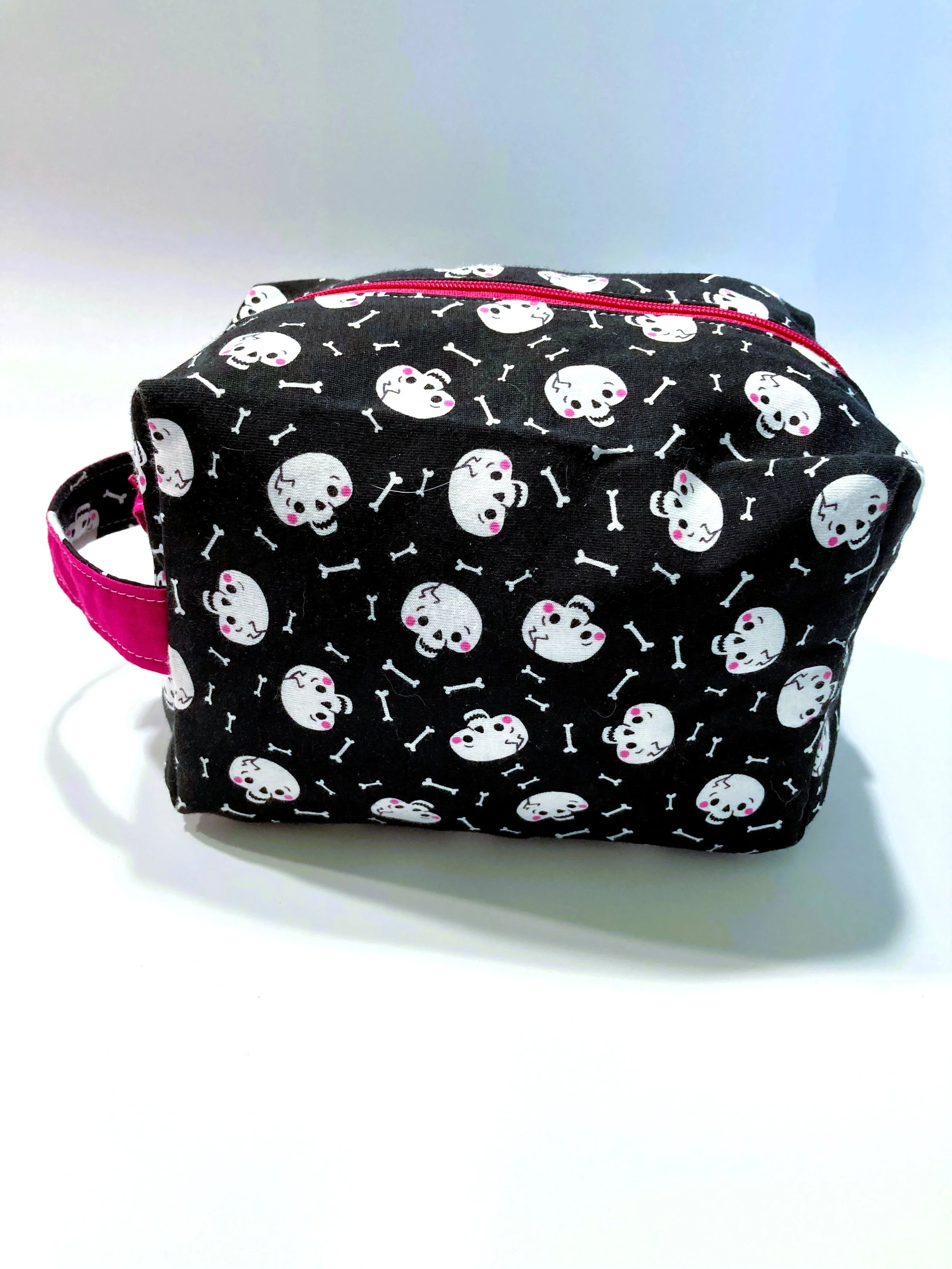 Creepy Cute Skull and Bones Travel Cosmetic Bag Pastel Goth Coquette Pink Bows Makeup Case Front View.jpeg