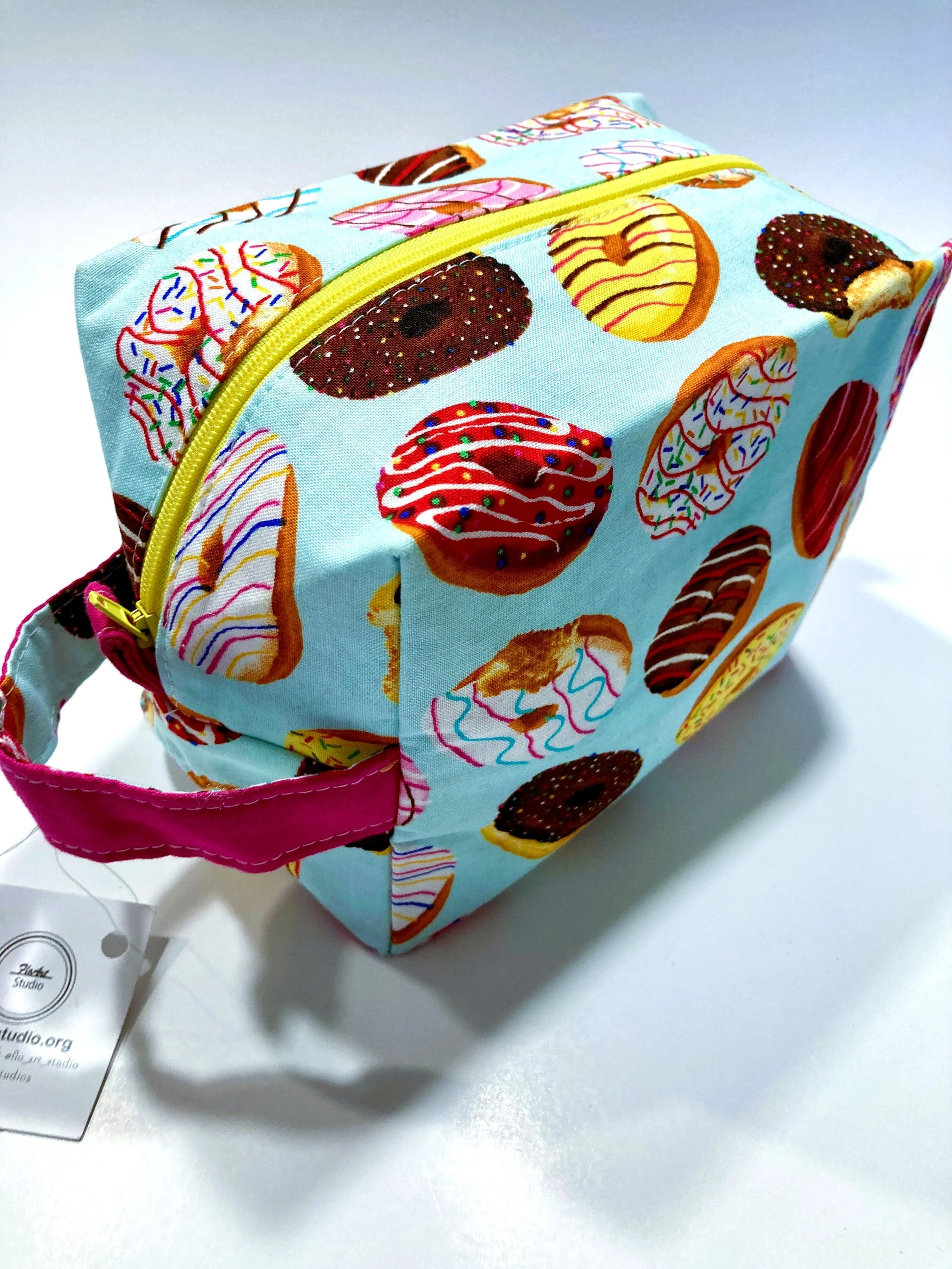 Bright Donuts Print Travel Cosmetic Bag Vibrant Sprinkle Pattern Makeup Case with Hot Pink Interior View Handle Side View.jpeg