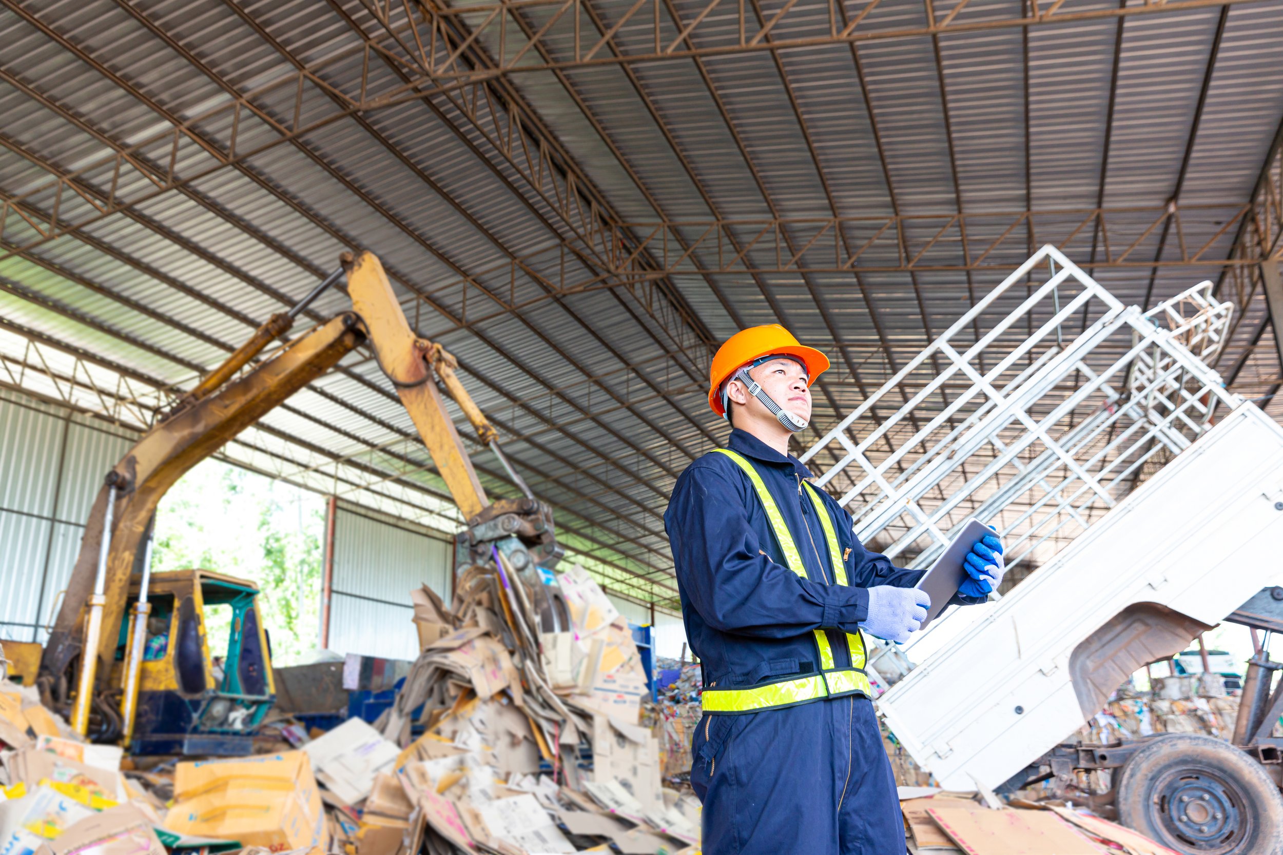 worker in a recycling facility in front of a front end loader