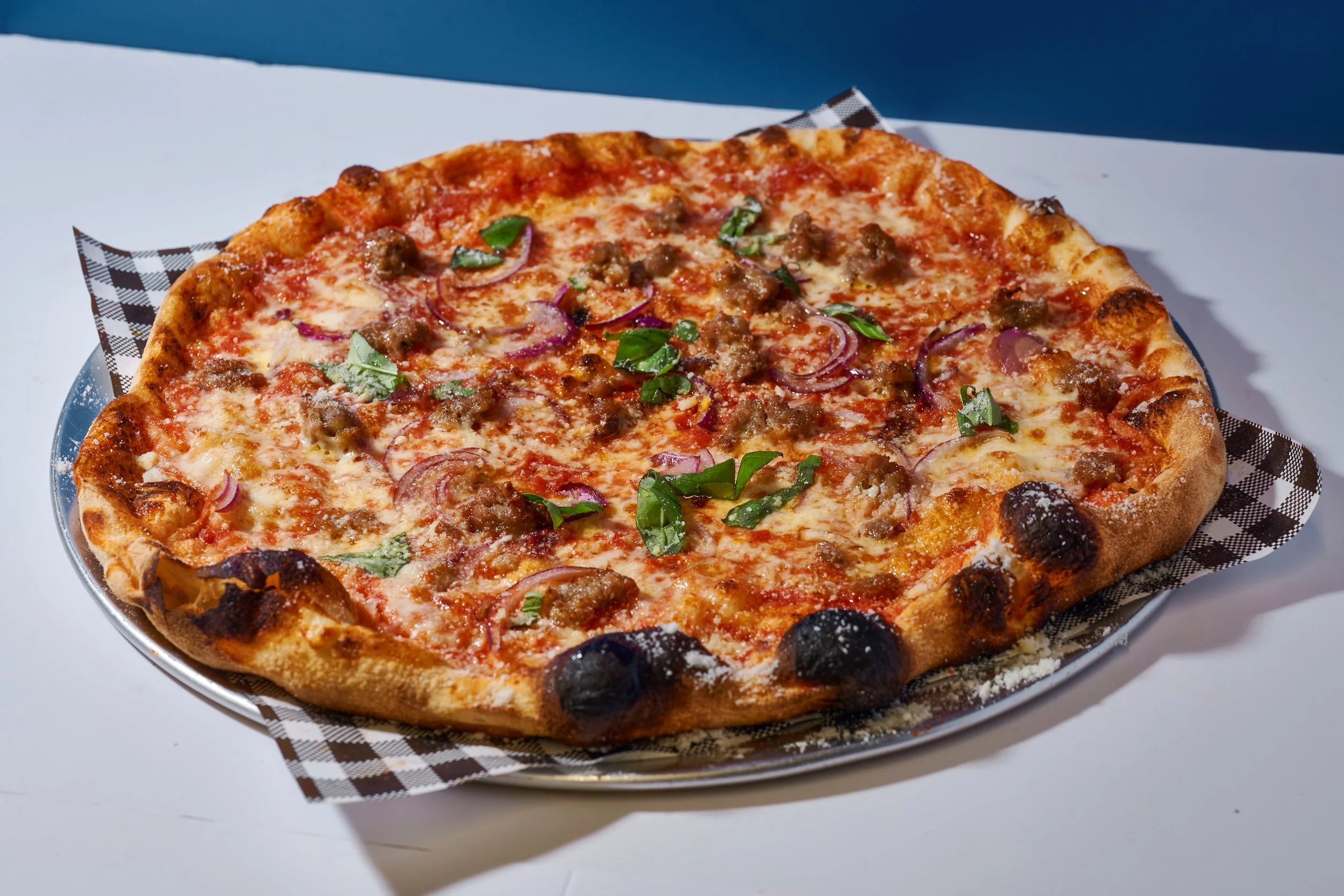 Lizard King with tomato sauce, aged mozzarella, fennel pork sausage, onions, pecorino, fresh basil