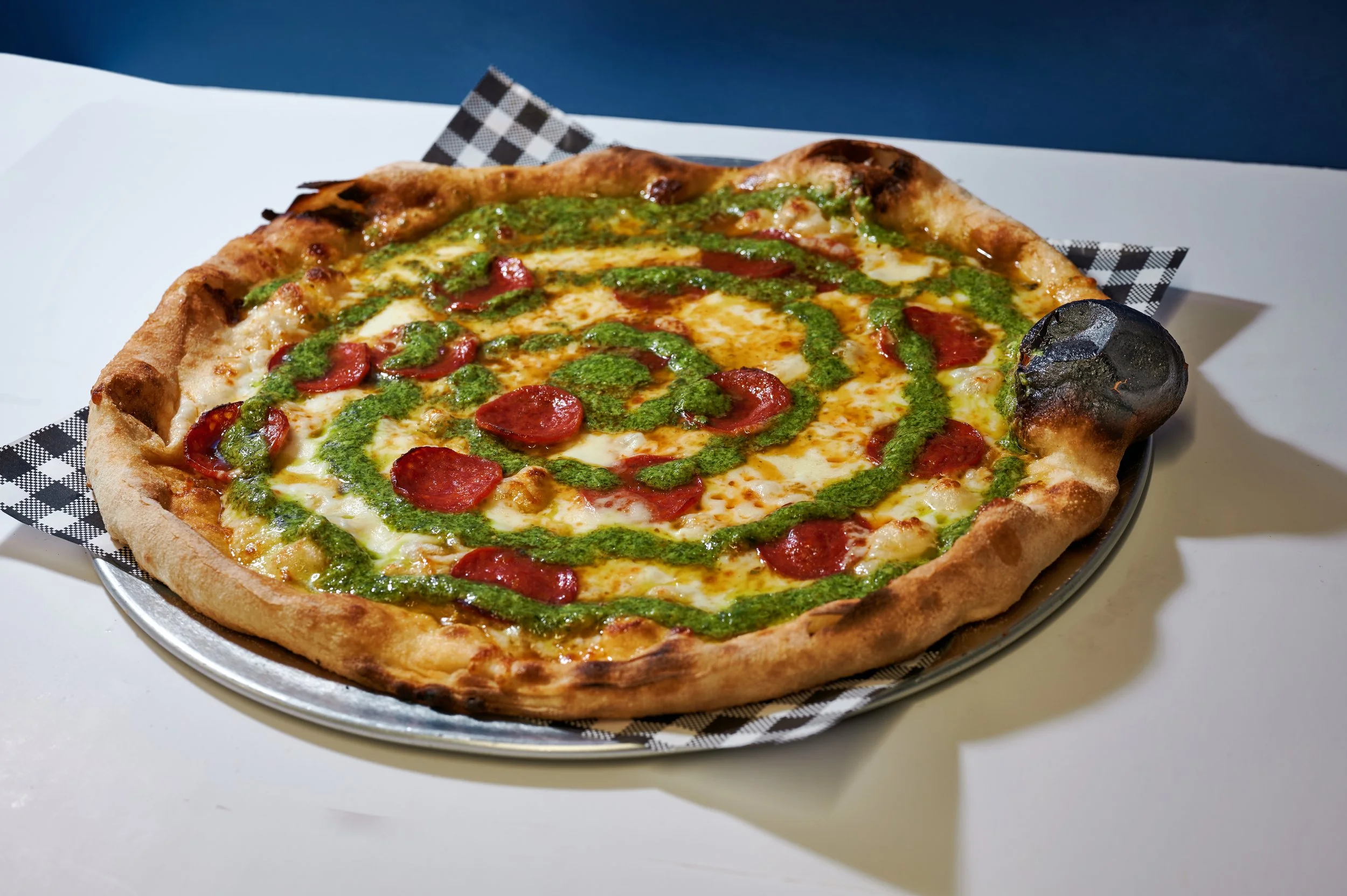 Funny How? with fresh and aged mozzarella, pepperoni, basil pesto swirl, pecorino