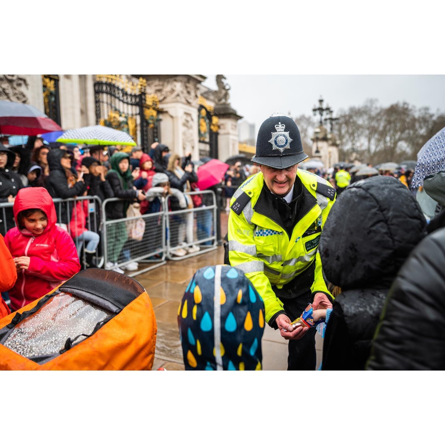 Image 1: A police officer hands out candy to children waiting to see the Changing of the Guard outside Buckingham Palace Friday morning. 

A crowd gathers outside Buckingham Palace Friday morning in hopes of seeing the Changing of the Guard. Due to h