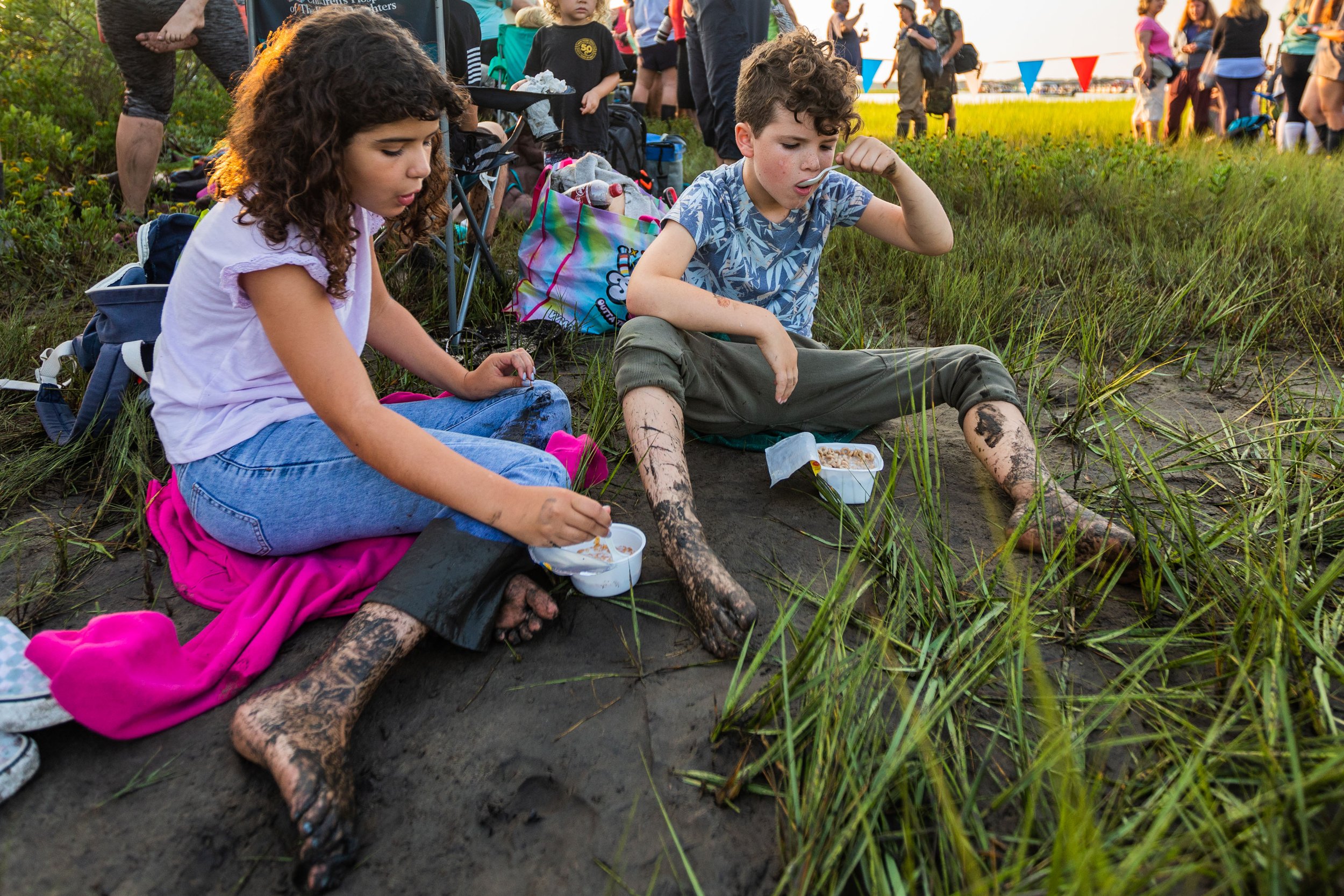  Tallula Loeb, 9, left, and brother Felix Loeb, 7, of Ojai, California, eat cereal at 6 a.m. after crossing the marsh to secure a spot to watch the Saltwater Cowboys swim ponies during slack tide from Assateague Island to Chincoteague Island on July 