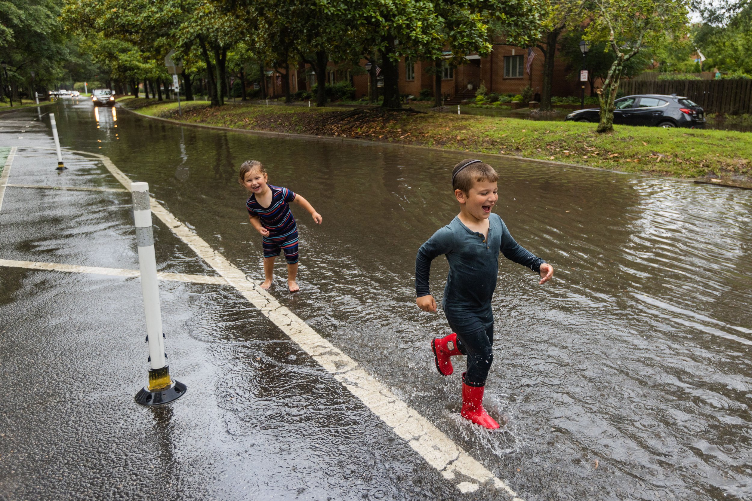  Benny Katz, 3, center, and brother Yossi Katz, 4, right, run in standing water near Maury High School at 5 p.m. after storms move through Norfolk, Va. on Wednesday, July 19, 2023. (Tess Crowley / The Virginian-Pilot) 