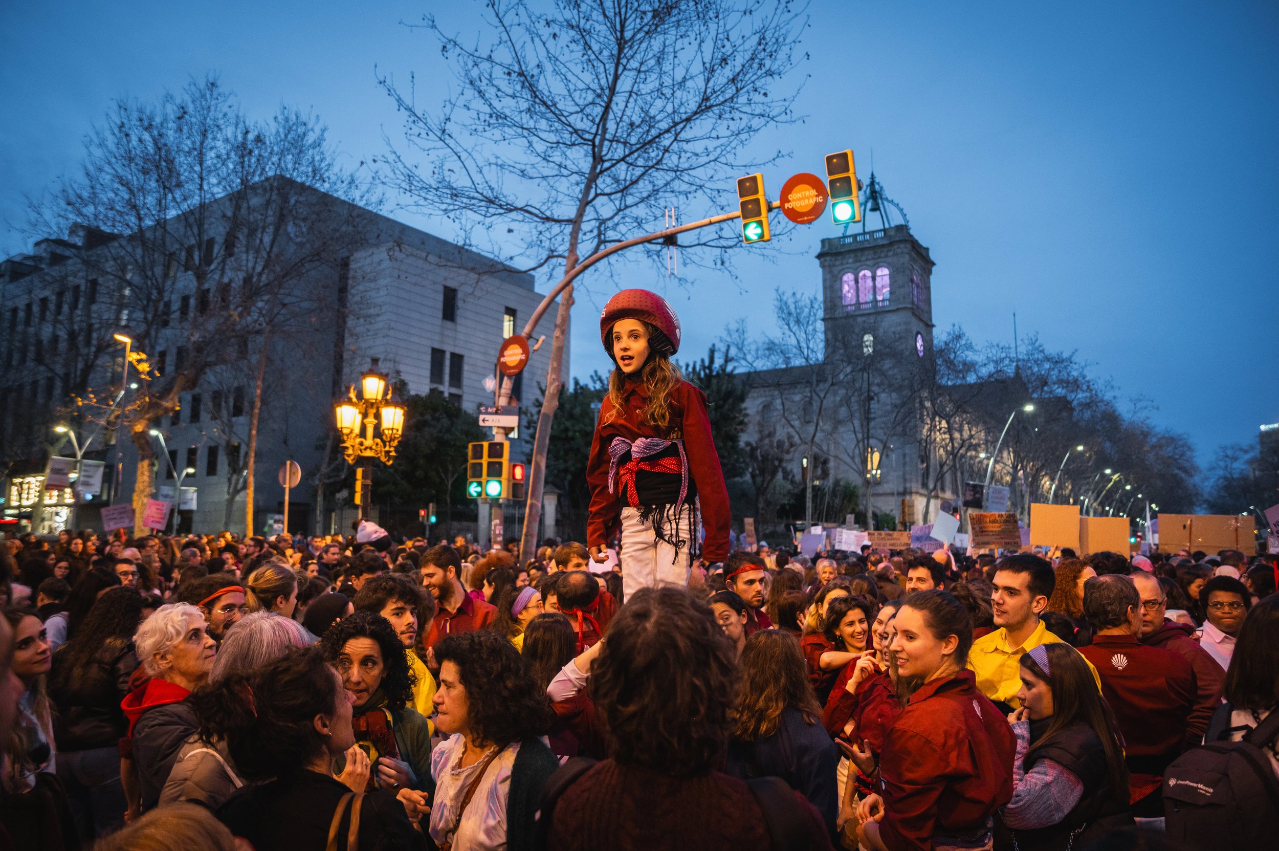  A child participating in a “castell,” the Catalan sport of building a human tower, looks at the crowd of thousands marching for International Women’s Day in Barcelona, Spain on Thursday, March 8, 2023. The child that climbs to the top of the tower i