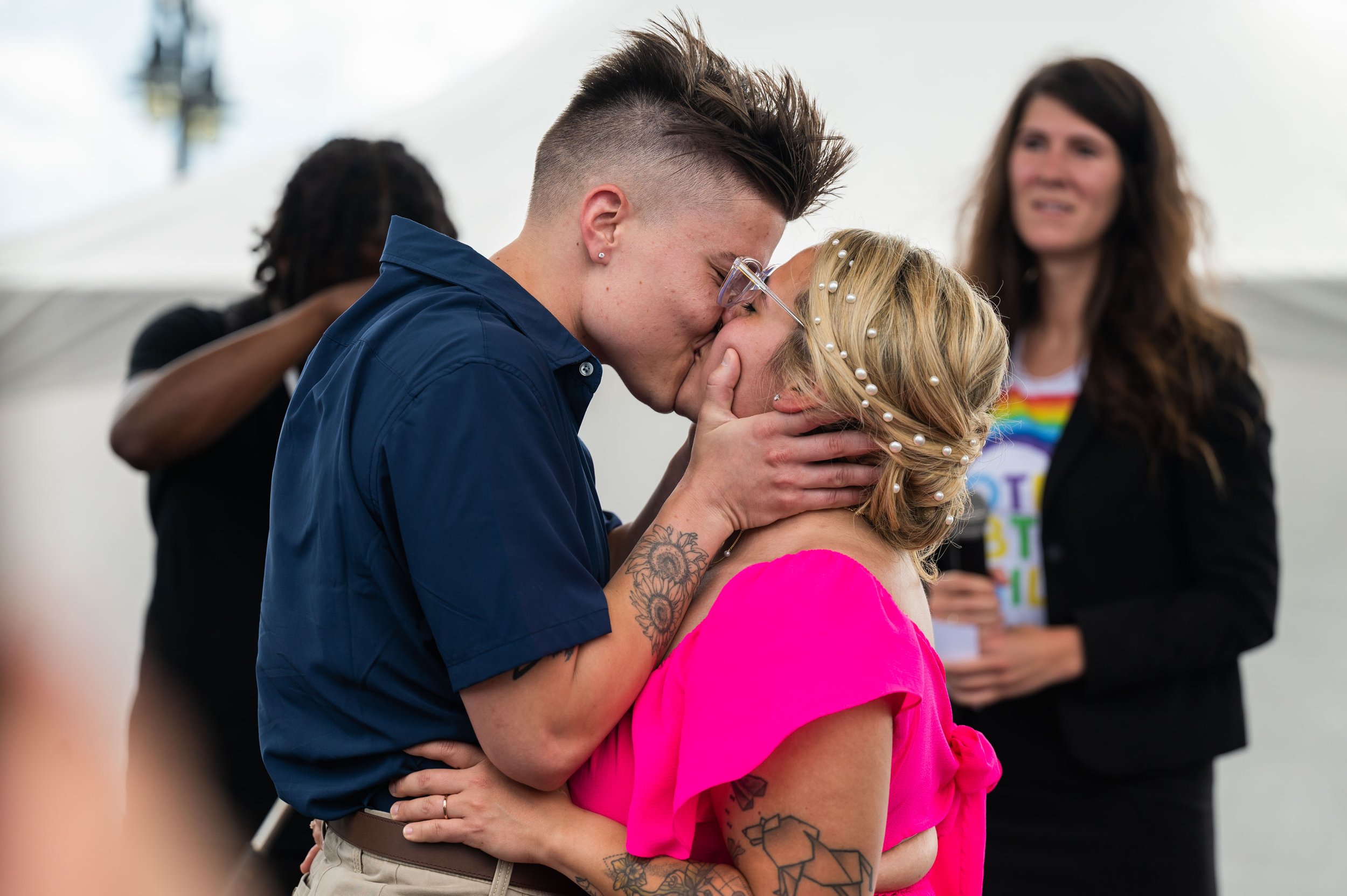  Landon Burford, left, and Joy Martinez share a kiss after their surprise wedding on the clubstage at Hampton Roads PrideFest at Town Point Park in Norfolk, Va. on Saturday, June 24, 2023. (Tess Crowley / The Virginian-Pilot) 