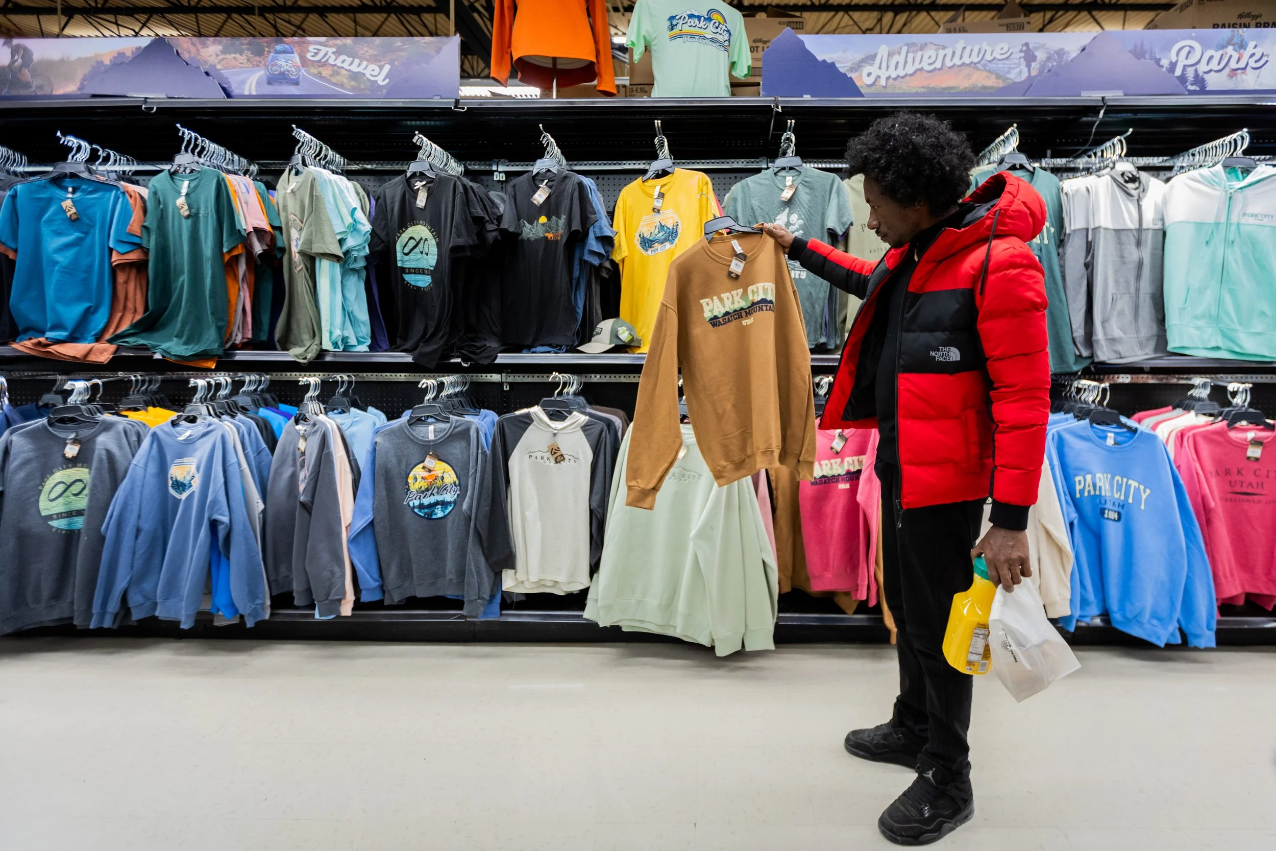  “Khartoum” director Ibrahim Snoopy shops for “Park City” shirts at the Fresh Market in Park City on Wednesday, Jan. 22, 2025. The four Sudanese directors traveled for 24 hours from Nairobi, Kenya, to Park City for their first feature-length document