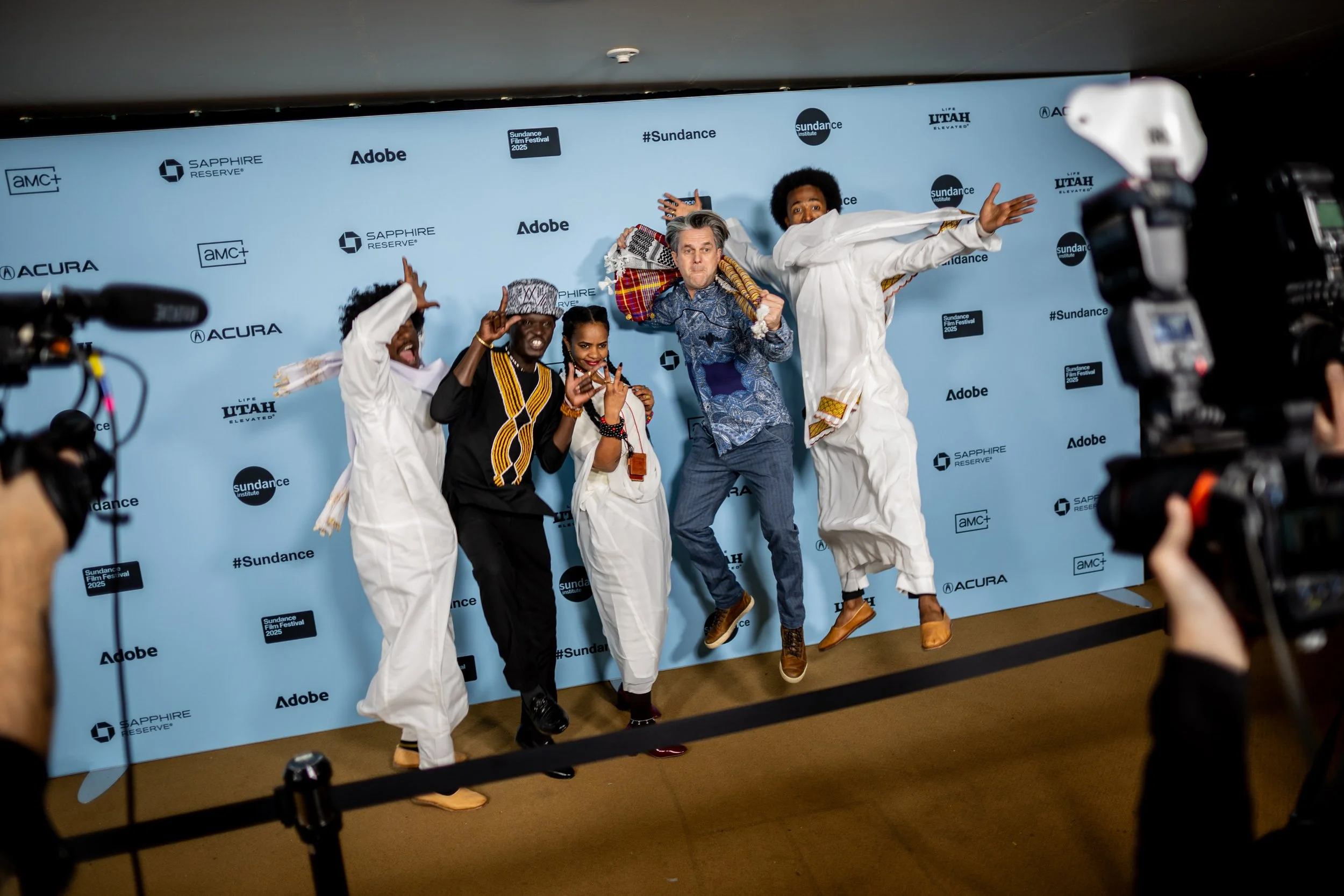  Journalists capture “Khartoum” directors Ibrahim Snoopy, Anas Saeed, Rawia Alhag, Phil Cox, and Timeea Mohamed Ahmed, from left, jumping on the red carpet before the world premiere of their documentary “Khartoum” at the Egyptian Theatre in Park City