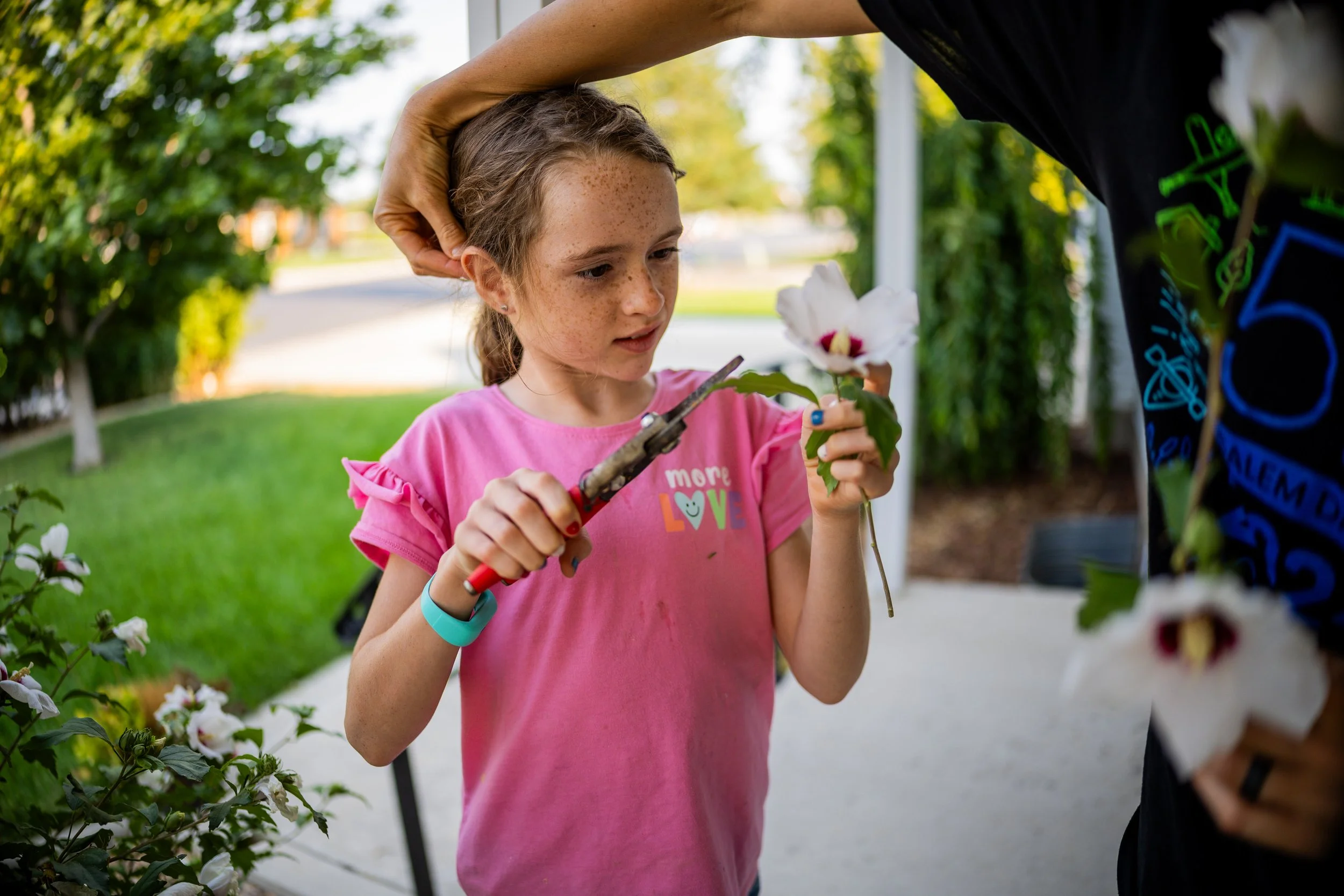  Alex Collett fixes her daughter Eva Collett’s, 9, hair as she picks Rose of Sharon flowers she will be entering in the Open Class floriculture competition at the upcoming Utah County Fair at her home in Spanish Fork on Monday, July 28, 2025.  