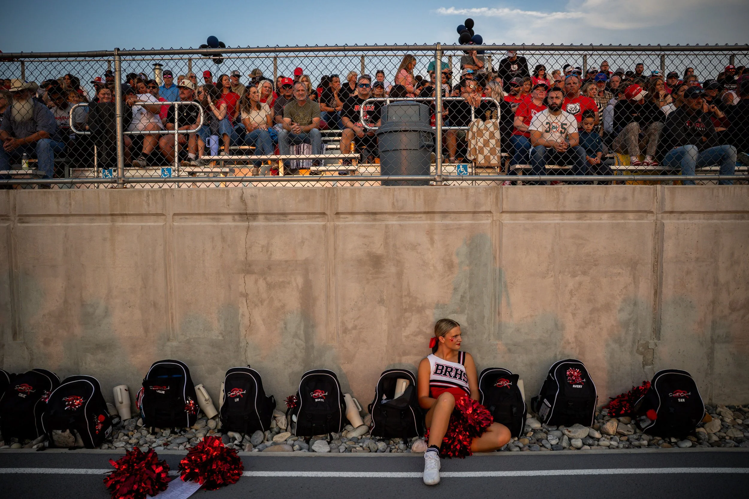  Bear River Bears cheerleader Brynley Menlove, 16, right, takes a break during a football game against the Box Elder Bees at Box Elder High School in Brigham City on Thursday, Aug. 28, 2025.   