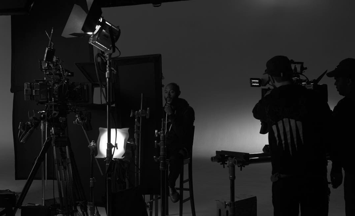 Nausha Turner on a professional production set surrounded by cinema cameras, lighting equipment, monitors, and crew, highlighting her work in art direction and production design.