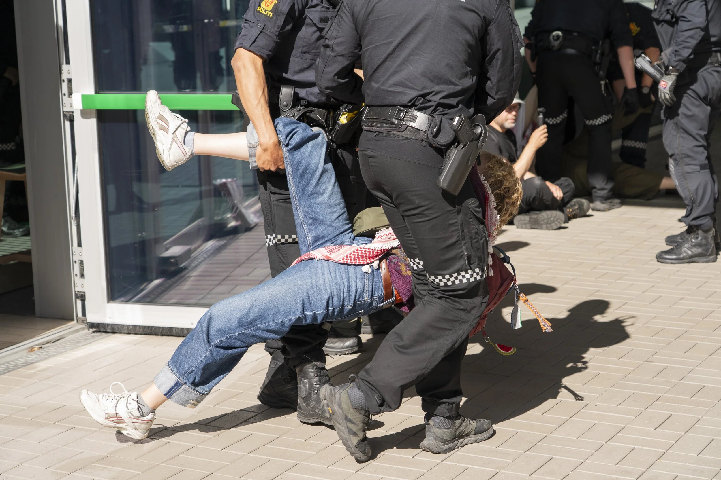 Protester being removed from the headquarters of Norges Bank