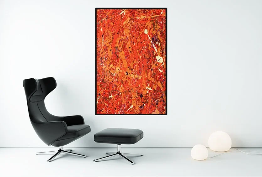A white room with a black chair and ottoman featuring Christian Valverde's first painting called "The First Expression."